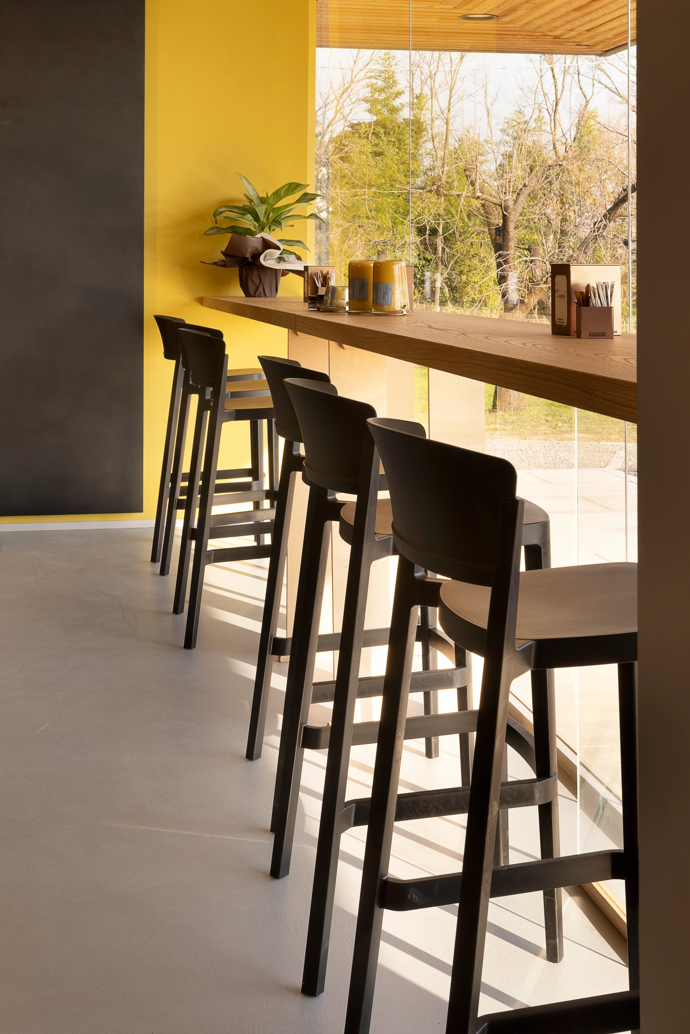 foto a colori bancone con grande vetrina e sgabelli