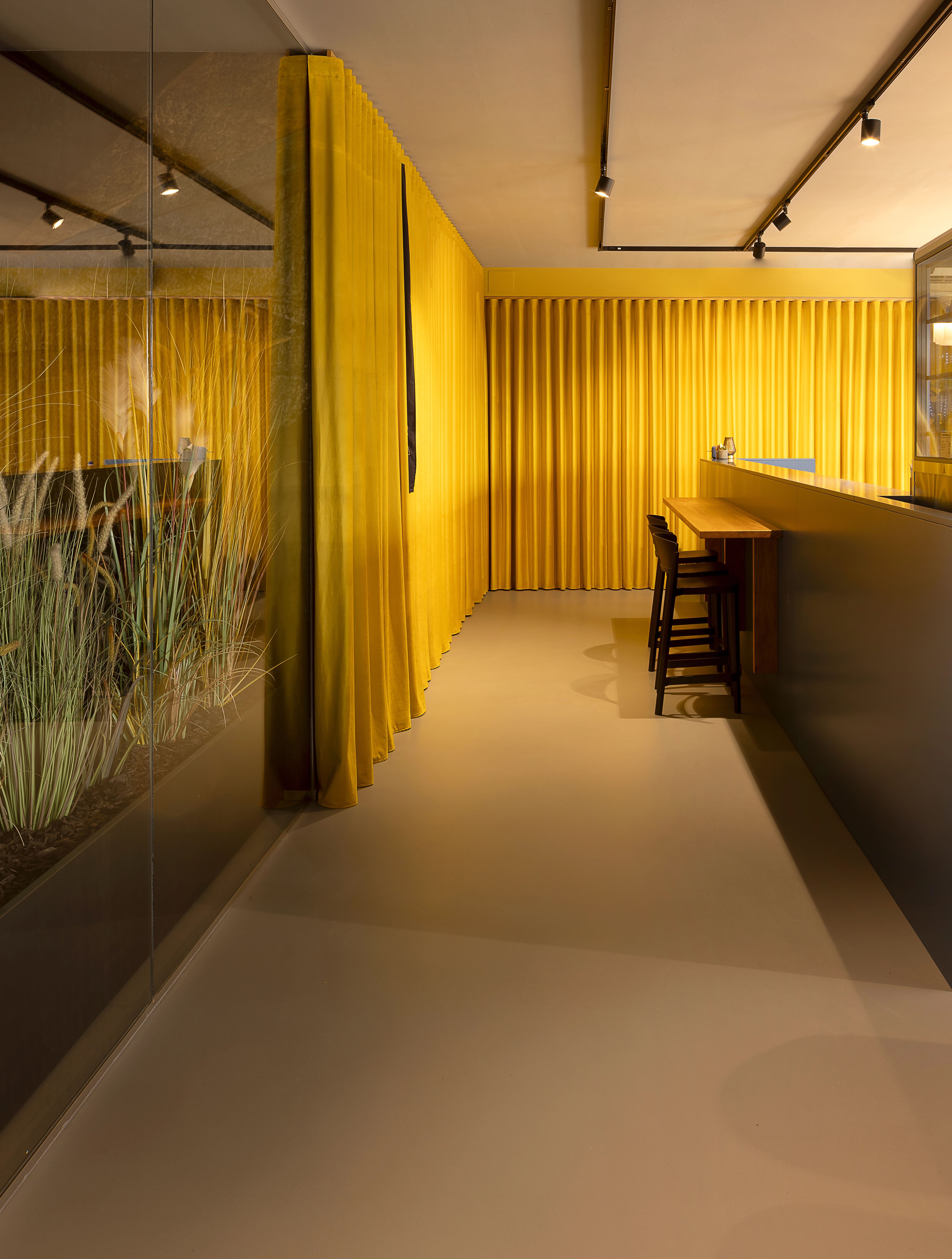 foto bancone pasticceria, colori giallo e blu, con due grandi lampade bianche