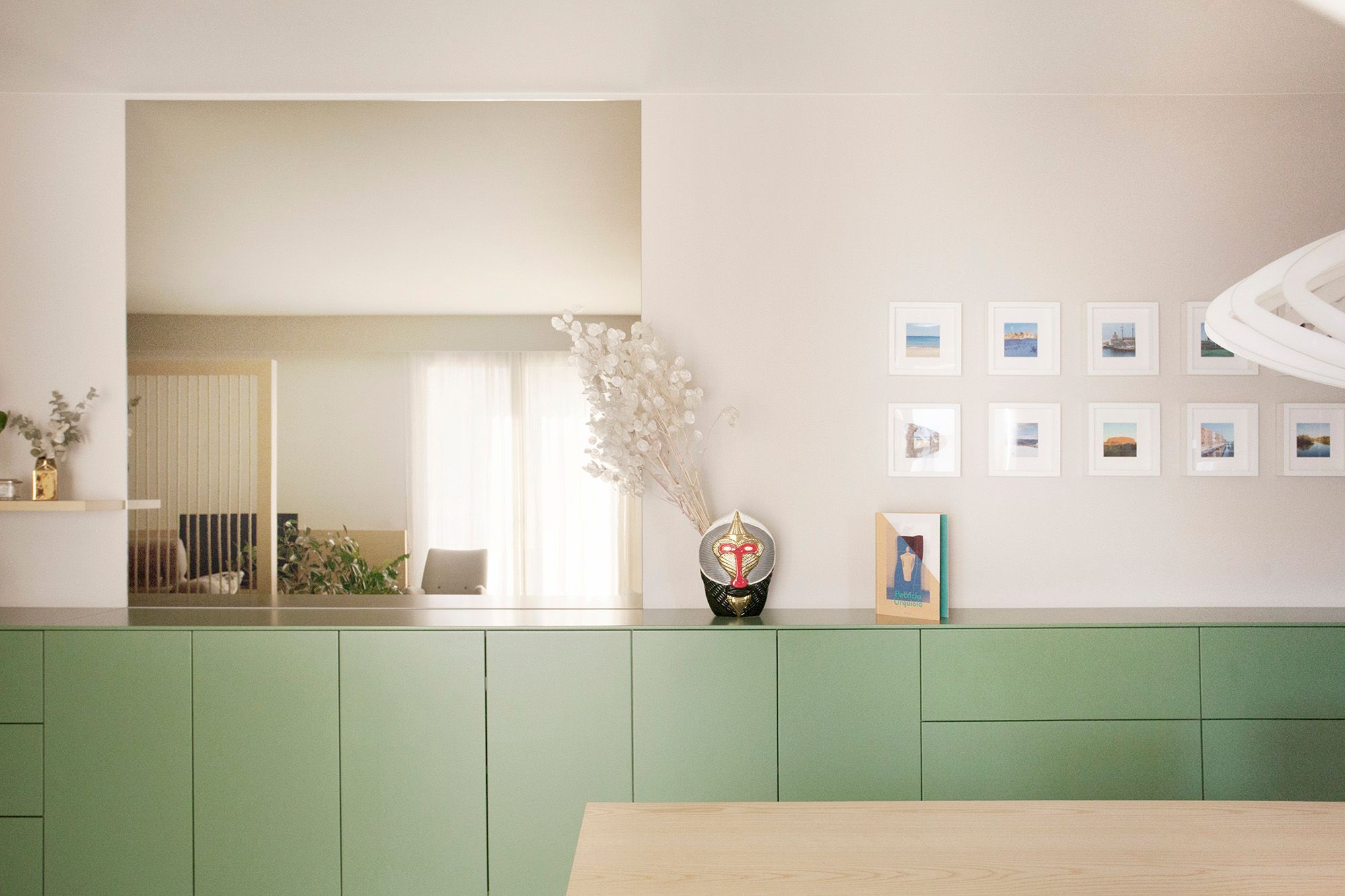 foto a colori con madia lunga verde e specchio sopra