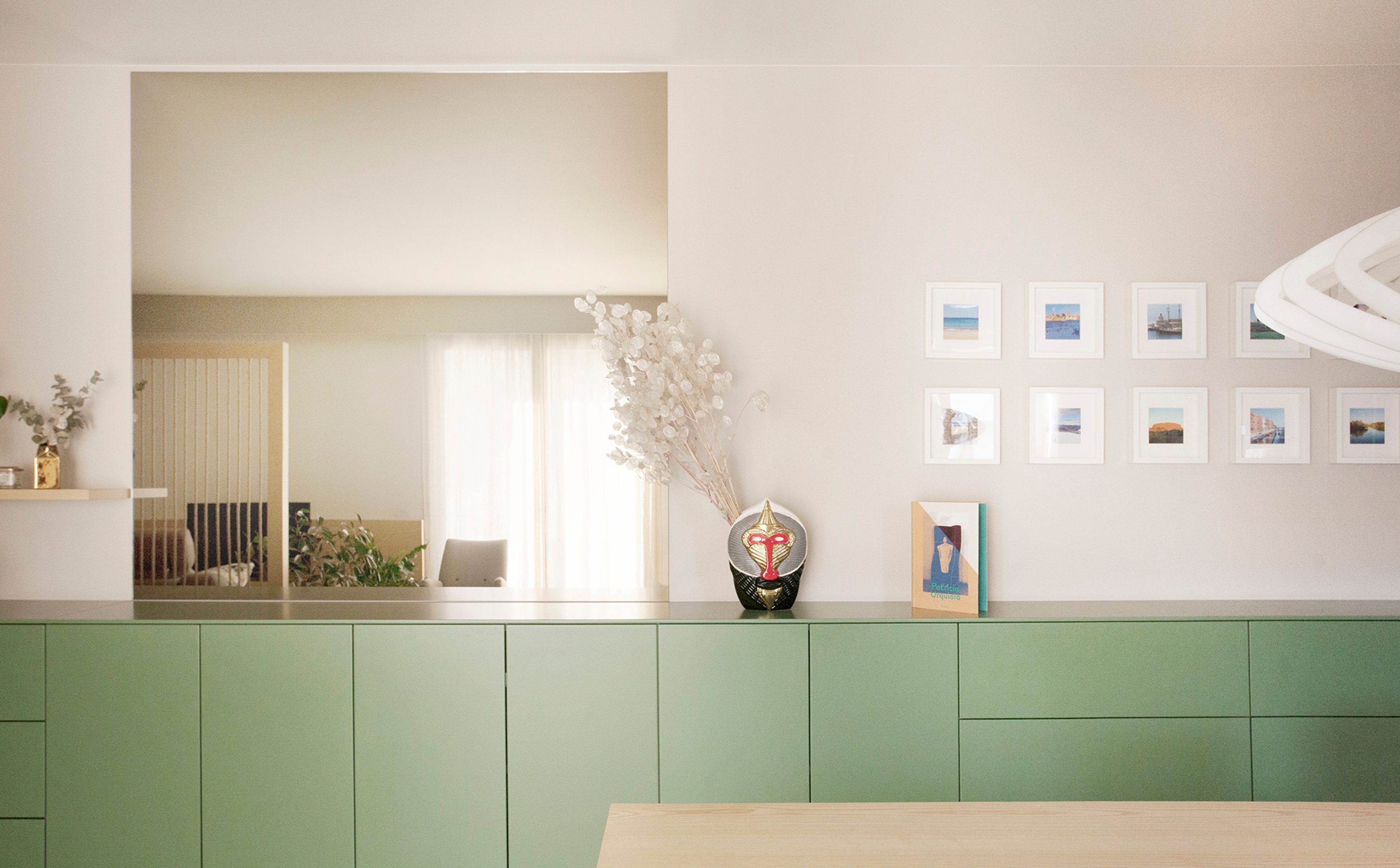 foto a colori con madia lunga verde e specchio sopra