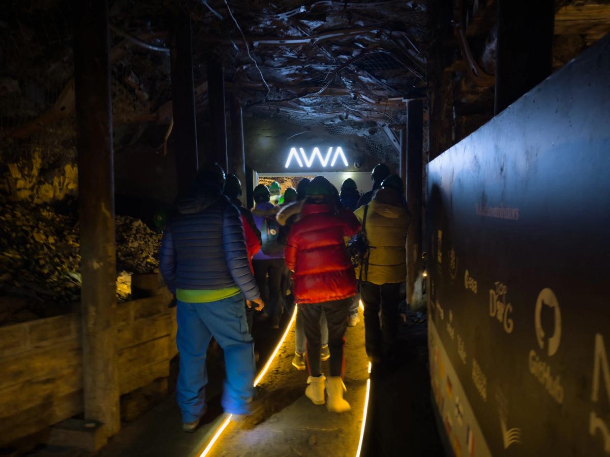 A man holding a piqlFilm strip inside a cave.