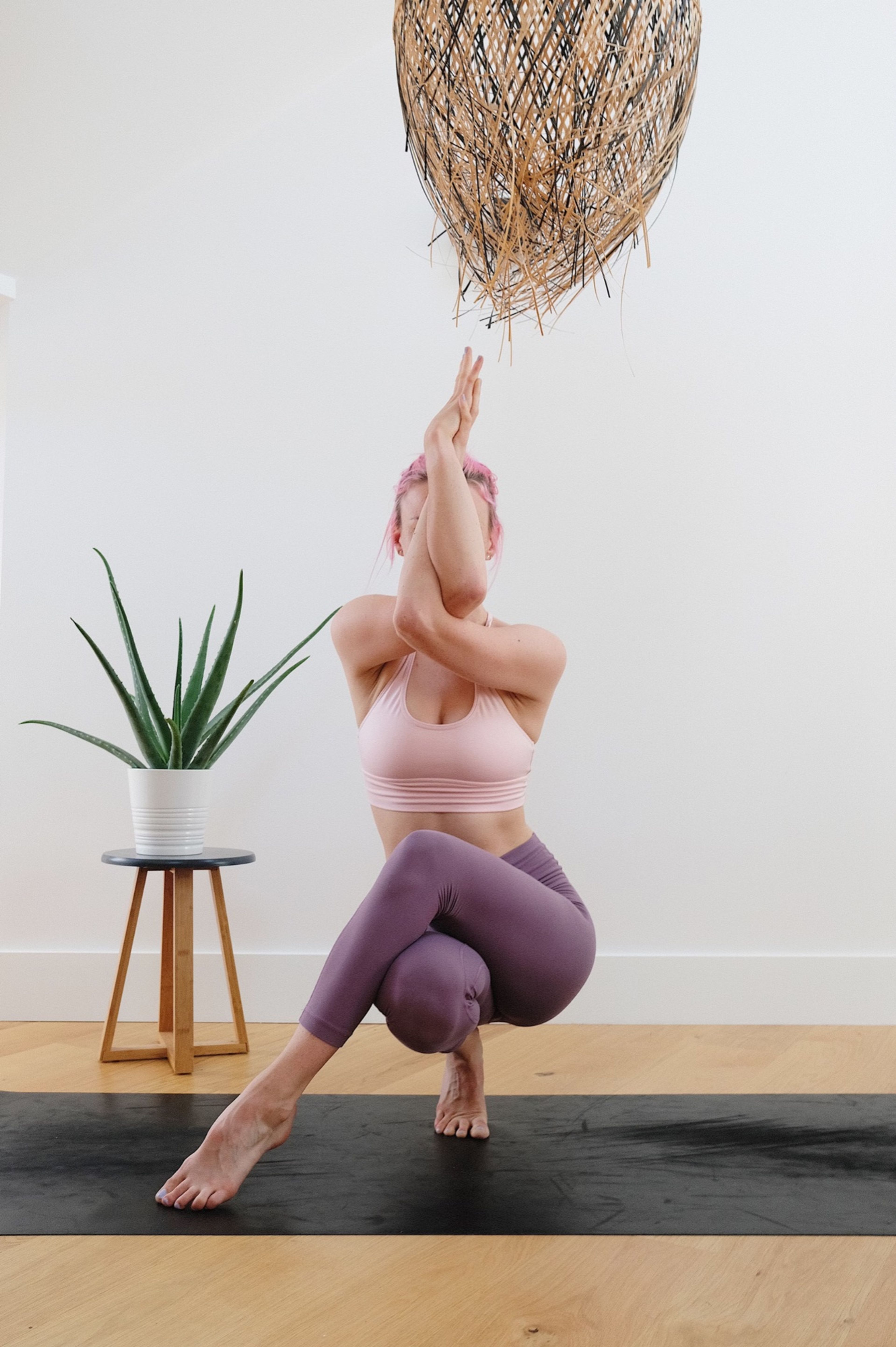 Woman in eagle pose with an aloe plant