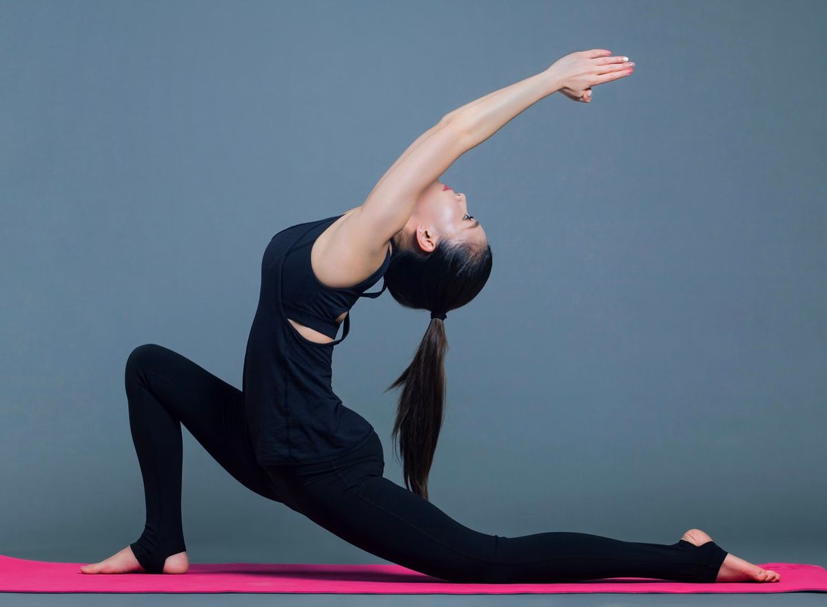 Woman in a deep side stretch on a yoga mat