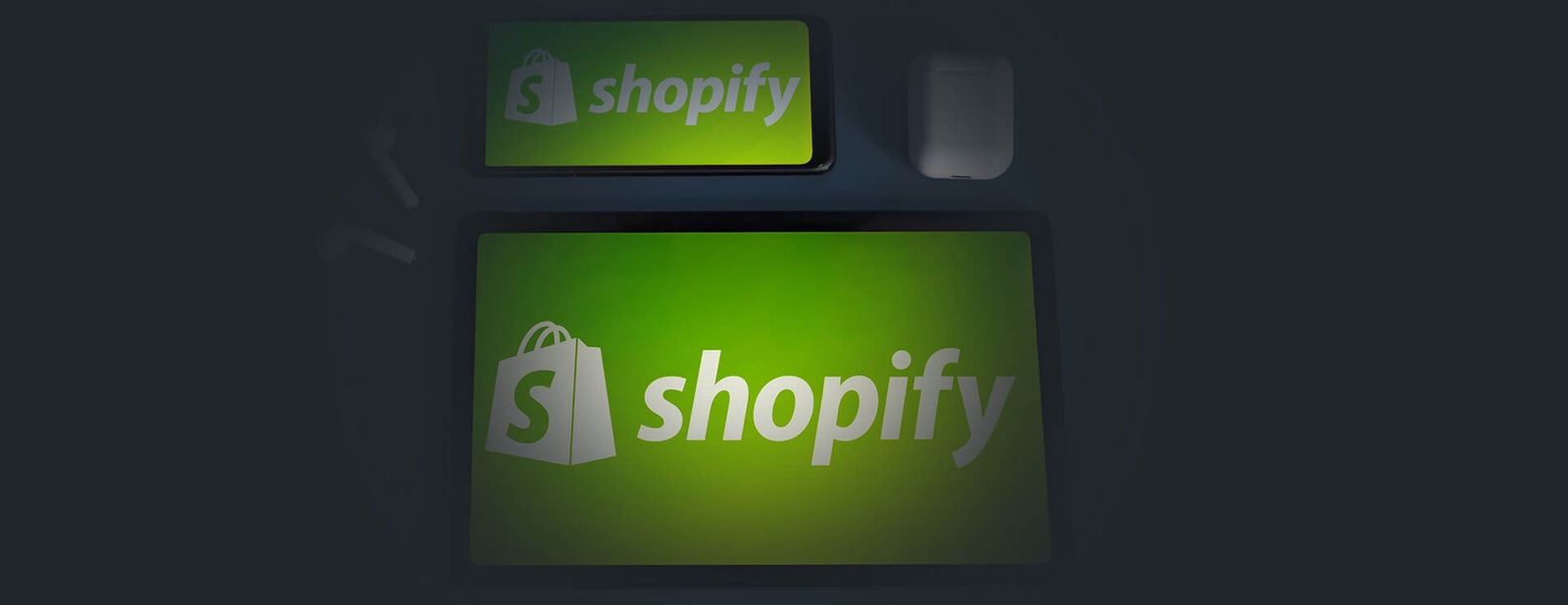 Logo Shopify affiché sur un smartphone et une tablette à côté d'écouteurs sans fil