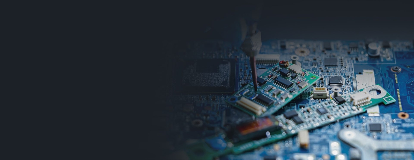 Hardware Integration Photo of a screwdriver being used on a close-up view of a circuit board with electronic components