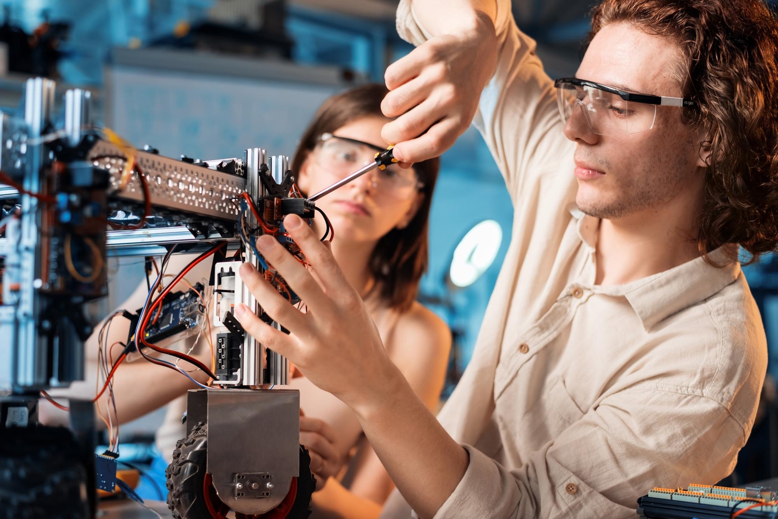 Photo de deux ingénieurs assemblant et testant des composants robotiques électroniques avec câblage