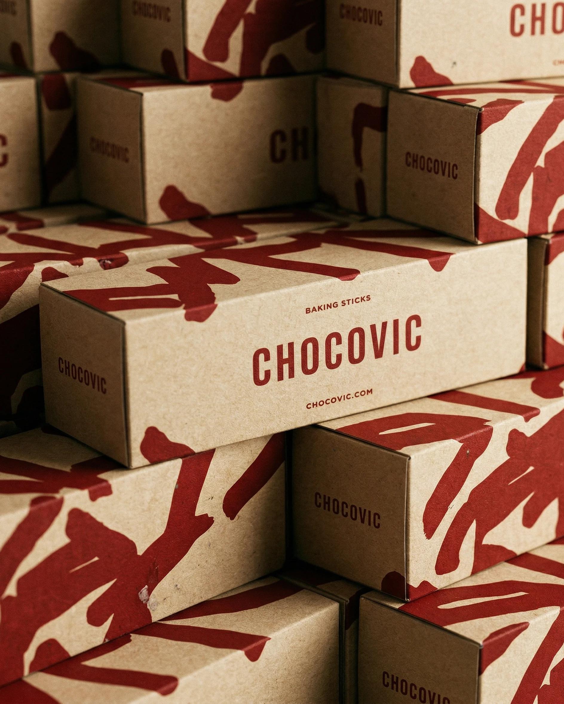 Chocovic — stacked Chocovic baking-stick boxes with the brush pattern, beside the website on a tablet on a bakery bench 1