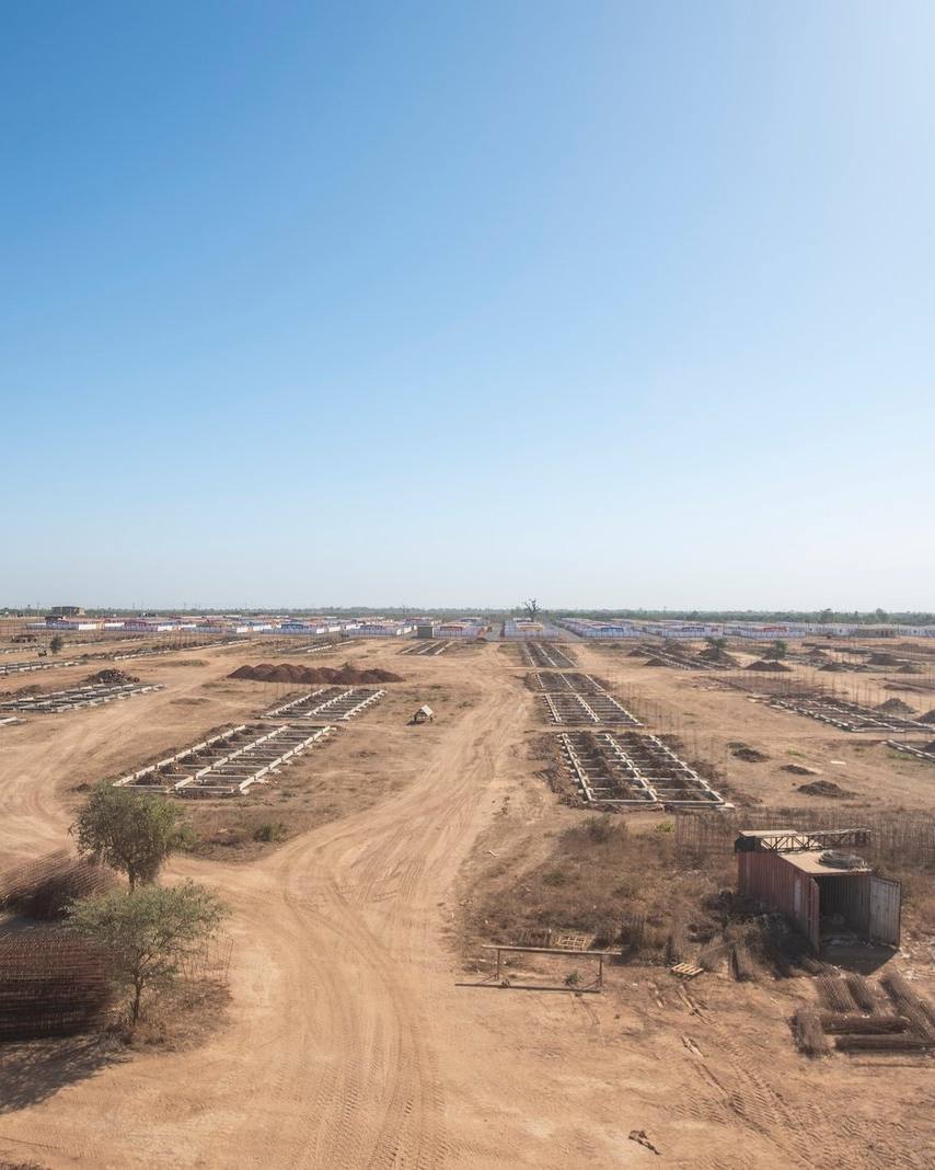 Vue en hauteur de parcelles viabilisées et de voies en terre sur un vaste terrain