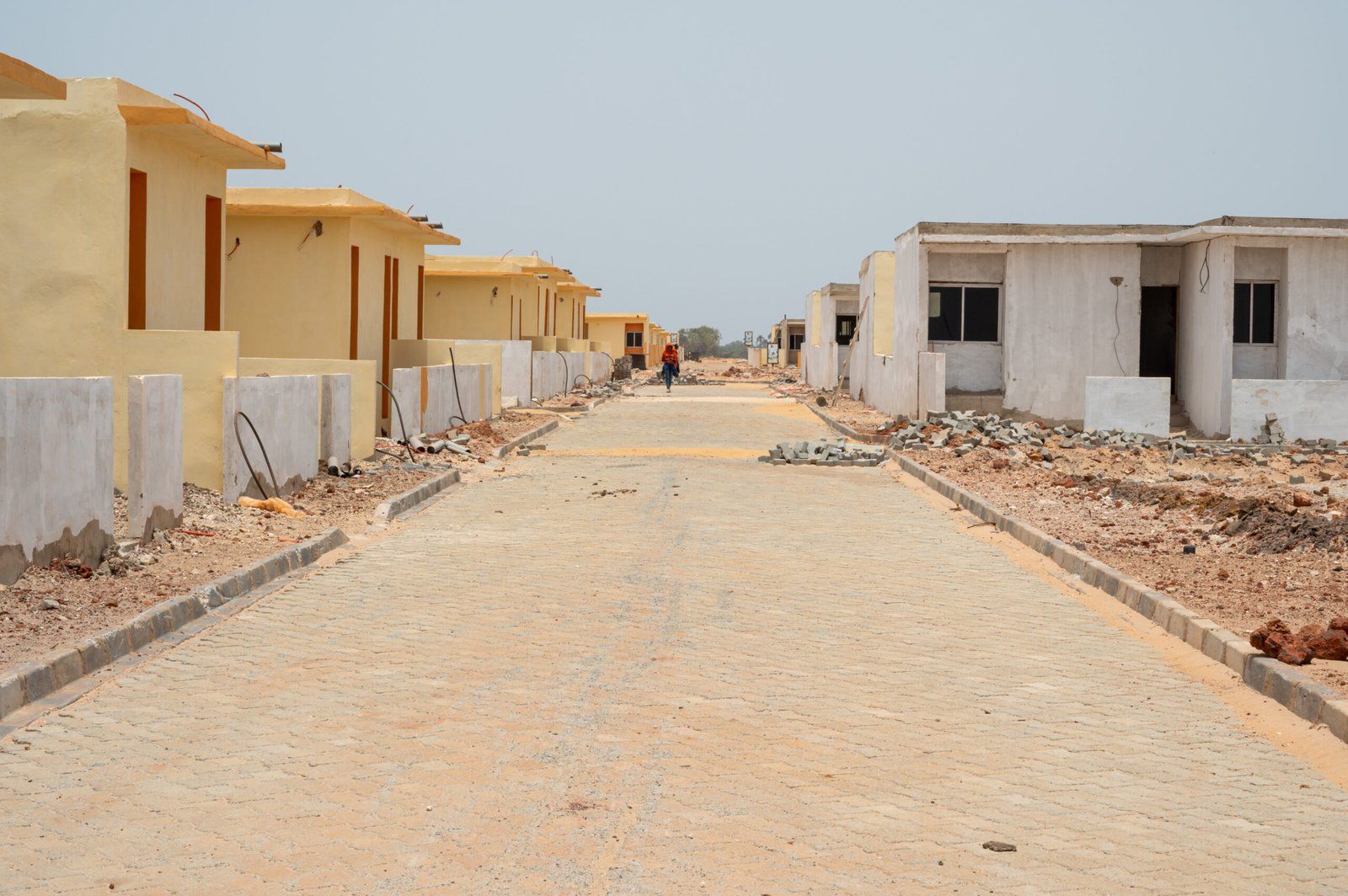 Rue pavée bordée de logements sur un site en cours d’aménagement
