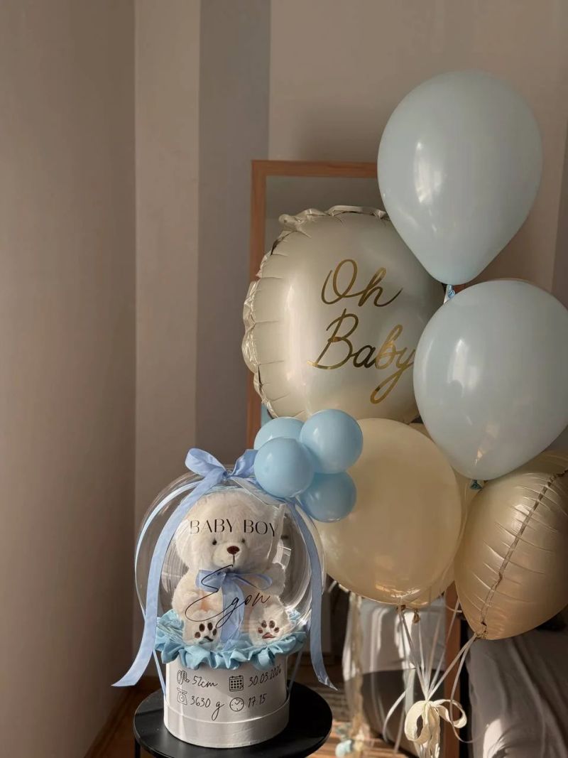 Širi kadar baby seta s boxom i visećim balonima.