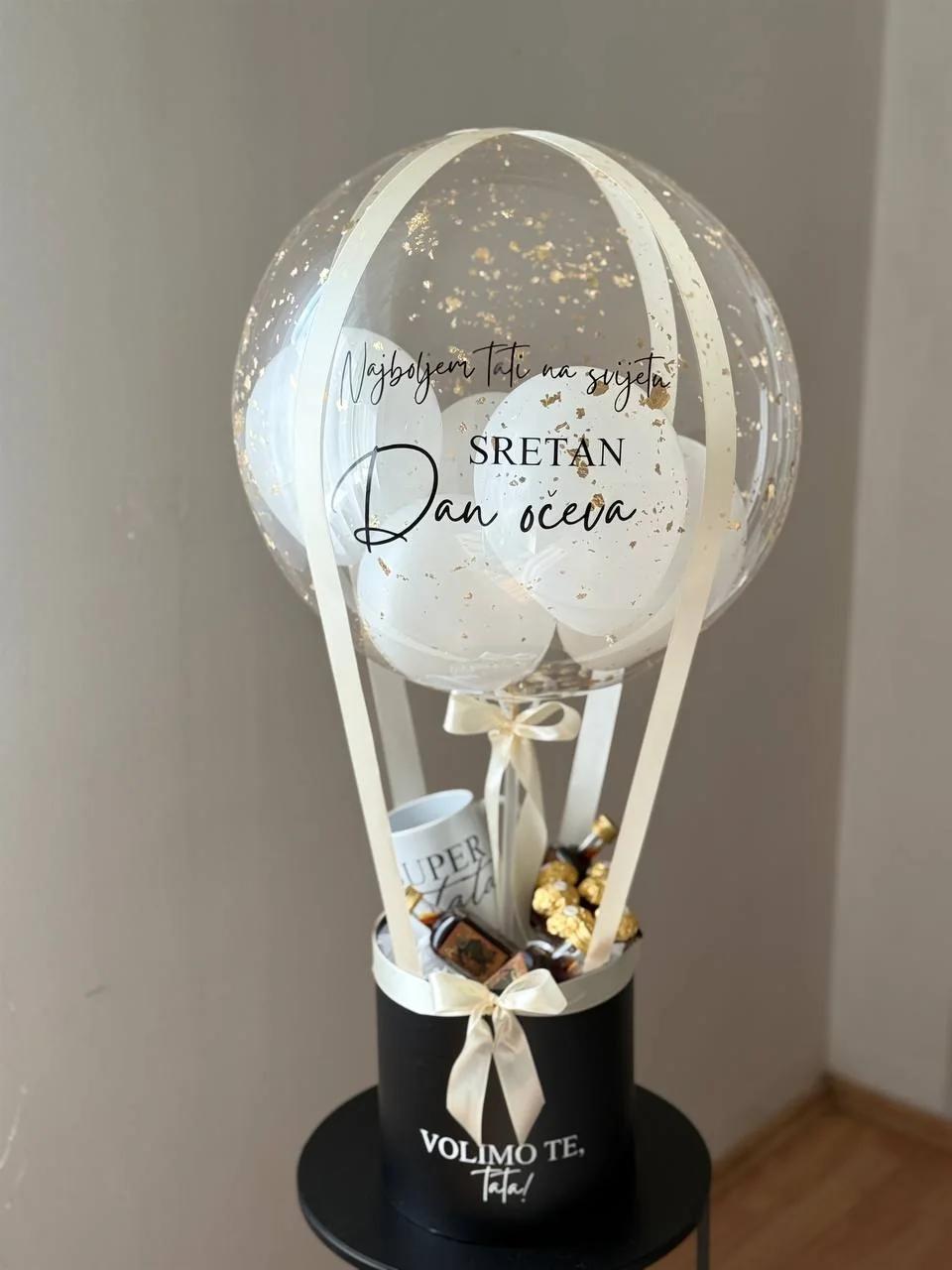 Visoki box sa šalicom, Ferrerom i prozirnim balonom sa zlatnim detaljima.