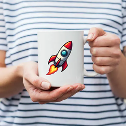 A woman in a striped T-shirt holding a mug with a cartoon-style rocket on it.