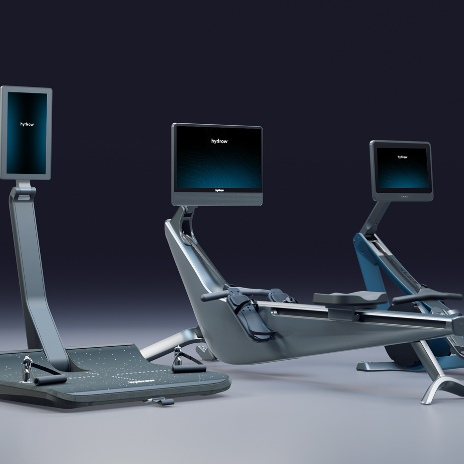 Three modern Hydrow exercise machines: a standing workout platform and two rowing machines, all with digital displays.