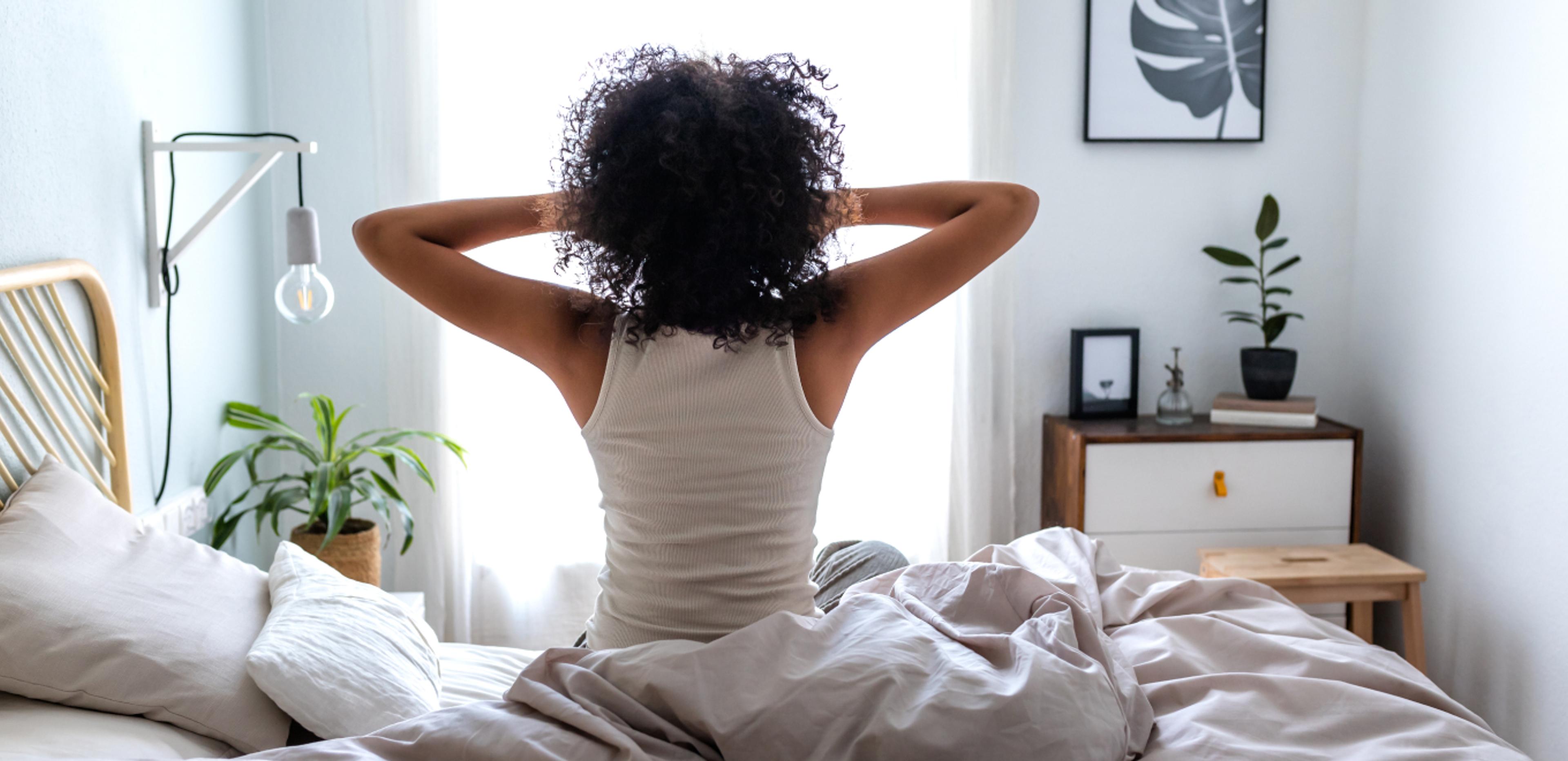 A photo of a woman stretching and waking up well rested