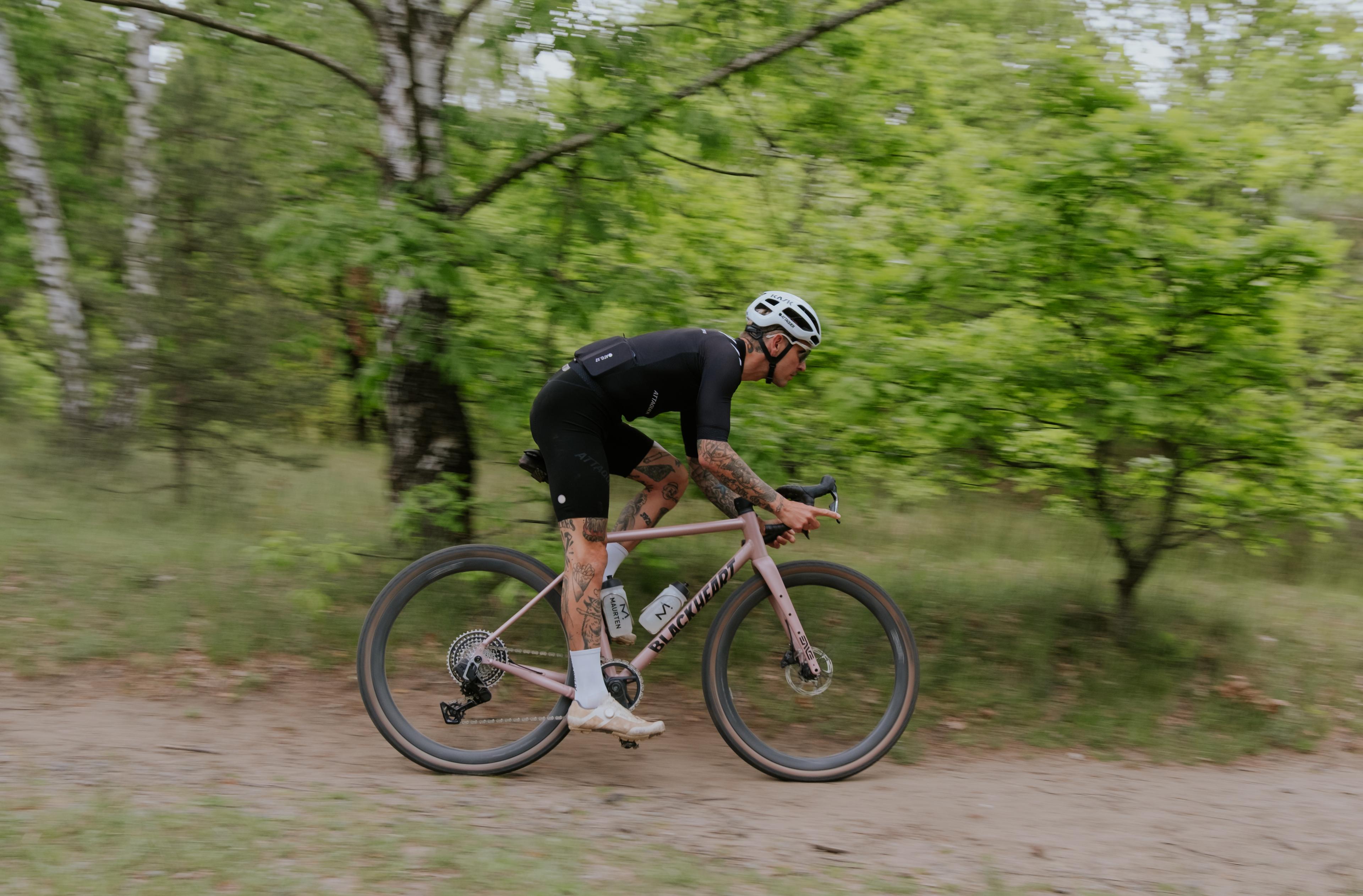 A silver road bike with black drop handlebars, disc brakes, and black wheels, on a white background.