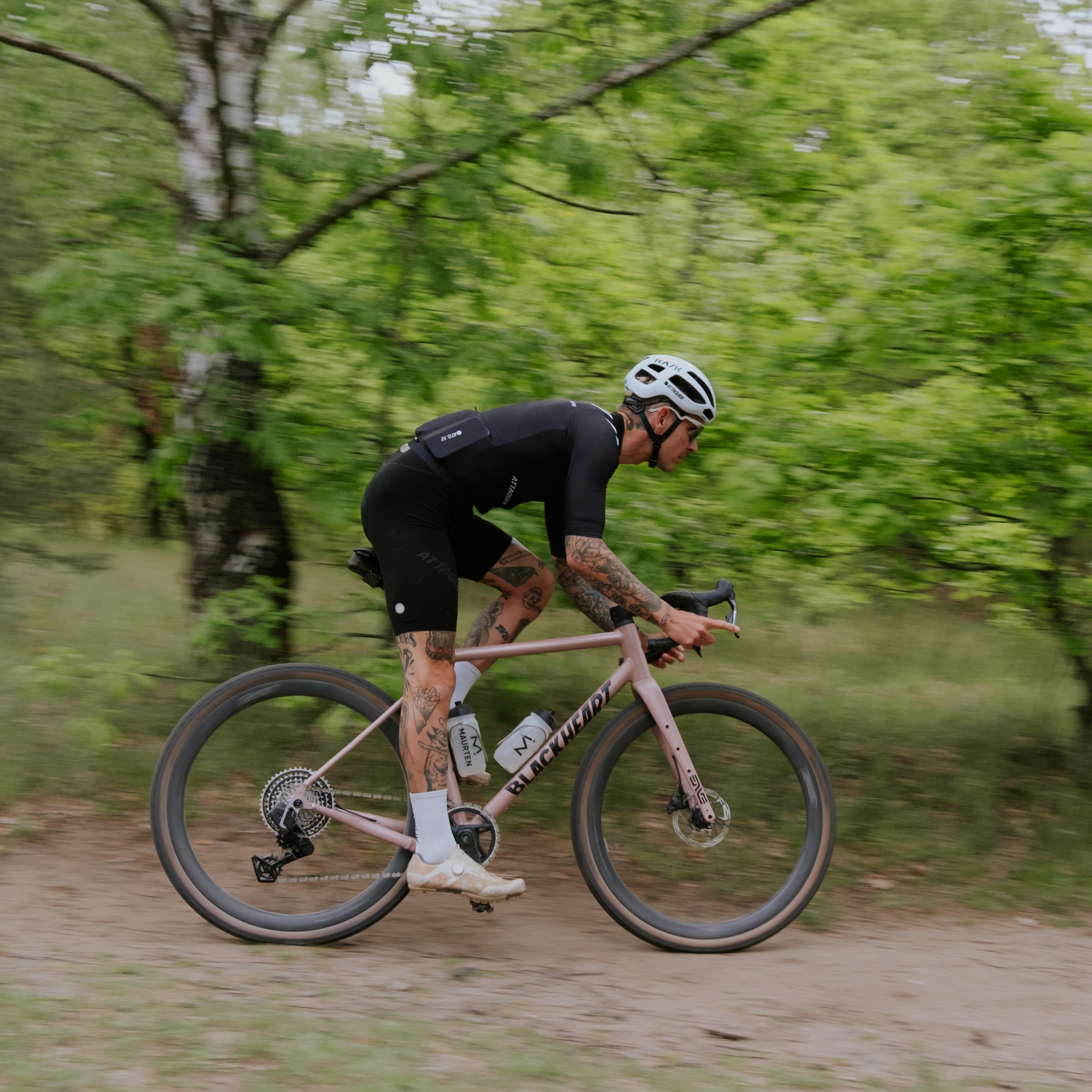 A silver road bike with black drop handlebars, disc brakes, and black wheels, on a white background.