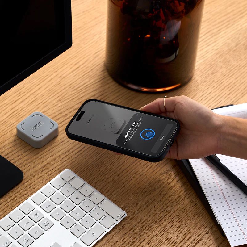 Hand holding iPhone out to activate Brick