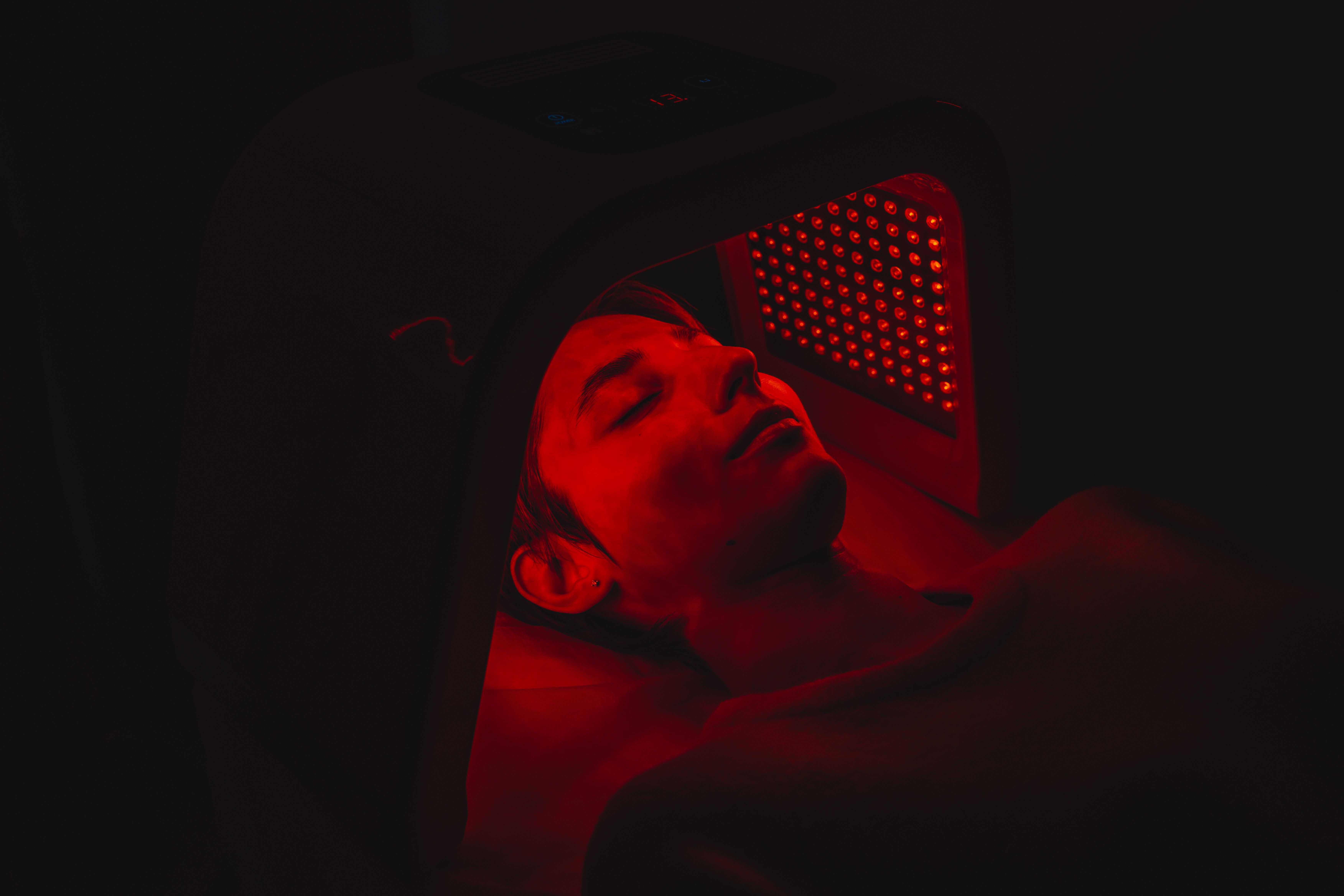Woman using red light therapy device