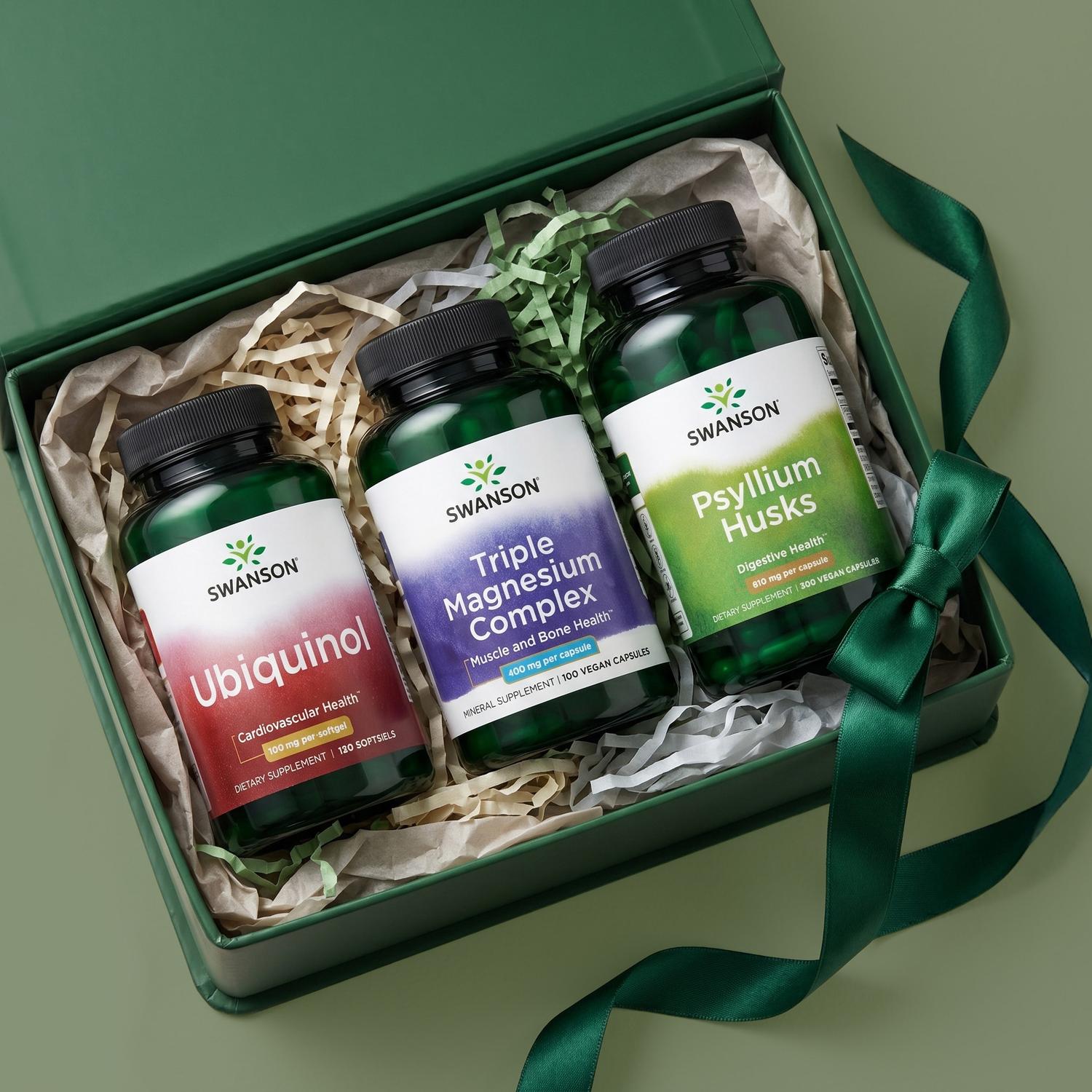 Three Swanson supplement bottles (Ubiquinol, Triple Magnesium Complex, Psyllium Husks) in an open green gift box with a matching ribbon.