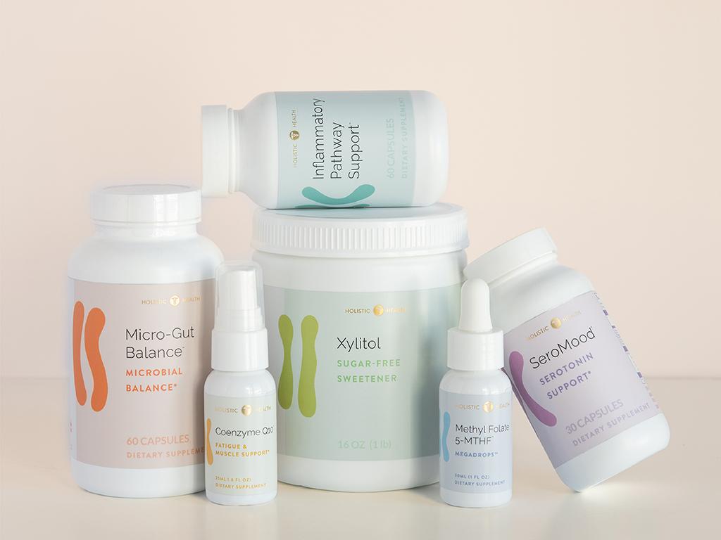 Various Holistic Health supplement bottles: Micro-Gut Balance, Coenzyme Q10, Xylitol, Methyl Folate, SeroMood, and Inflammatory Pathway Support.