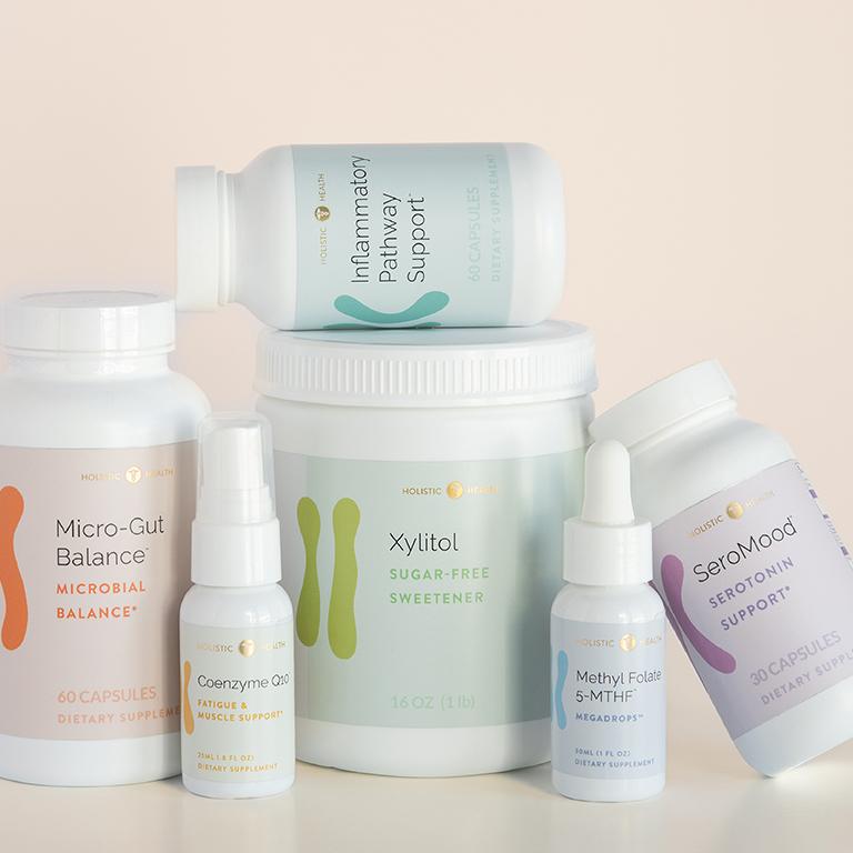 Various Holistic Health supplement bottles: Micro-Gut Balance, Coenzyme Q10, Xylitol, Methyl Folate, SeroMood, and Inflammatory Pathway Support.