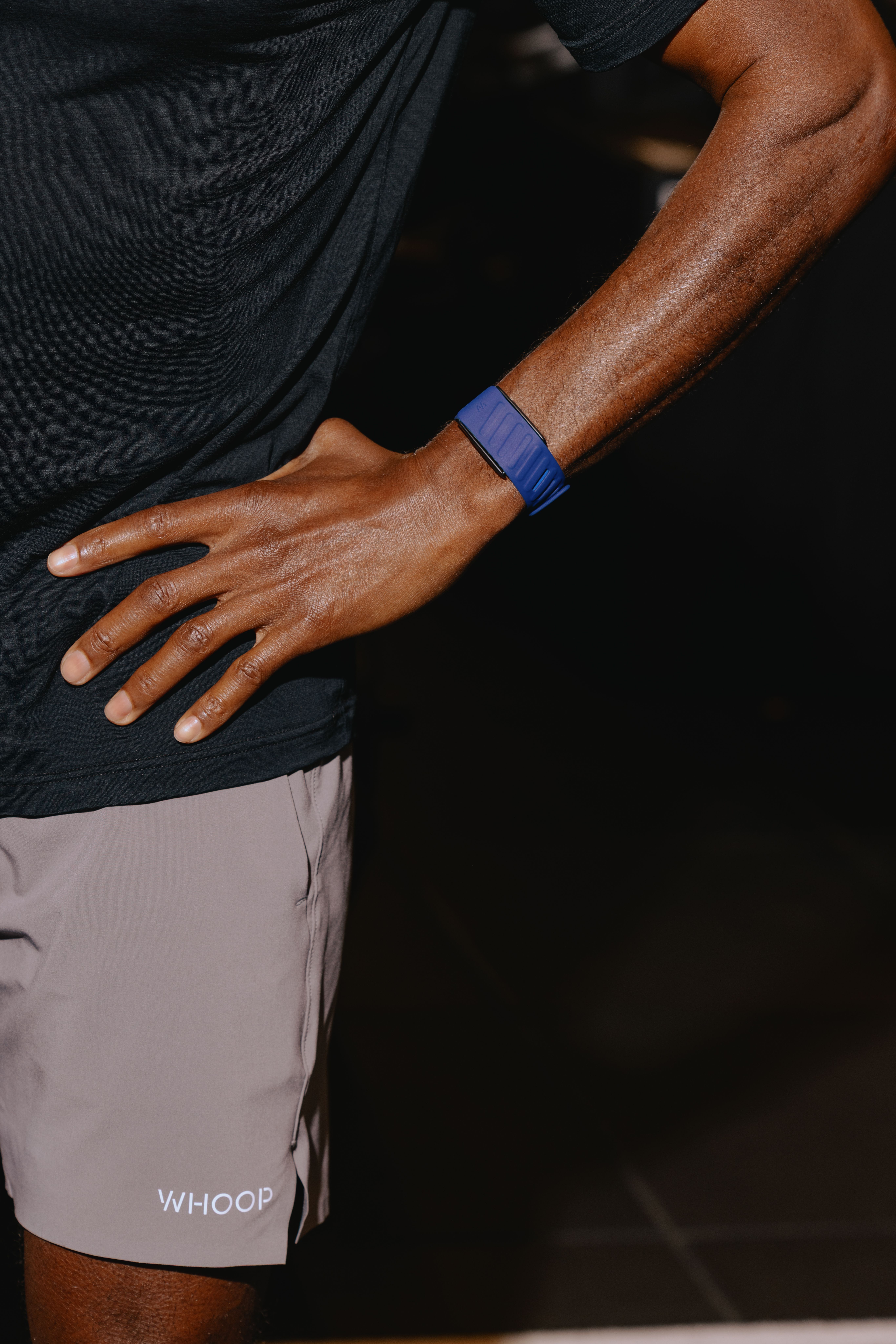 An athlete in WHOOP training kit wearing a blue WHOOP band on the wrist.