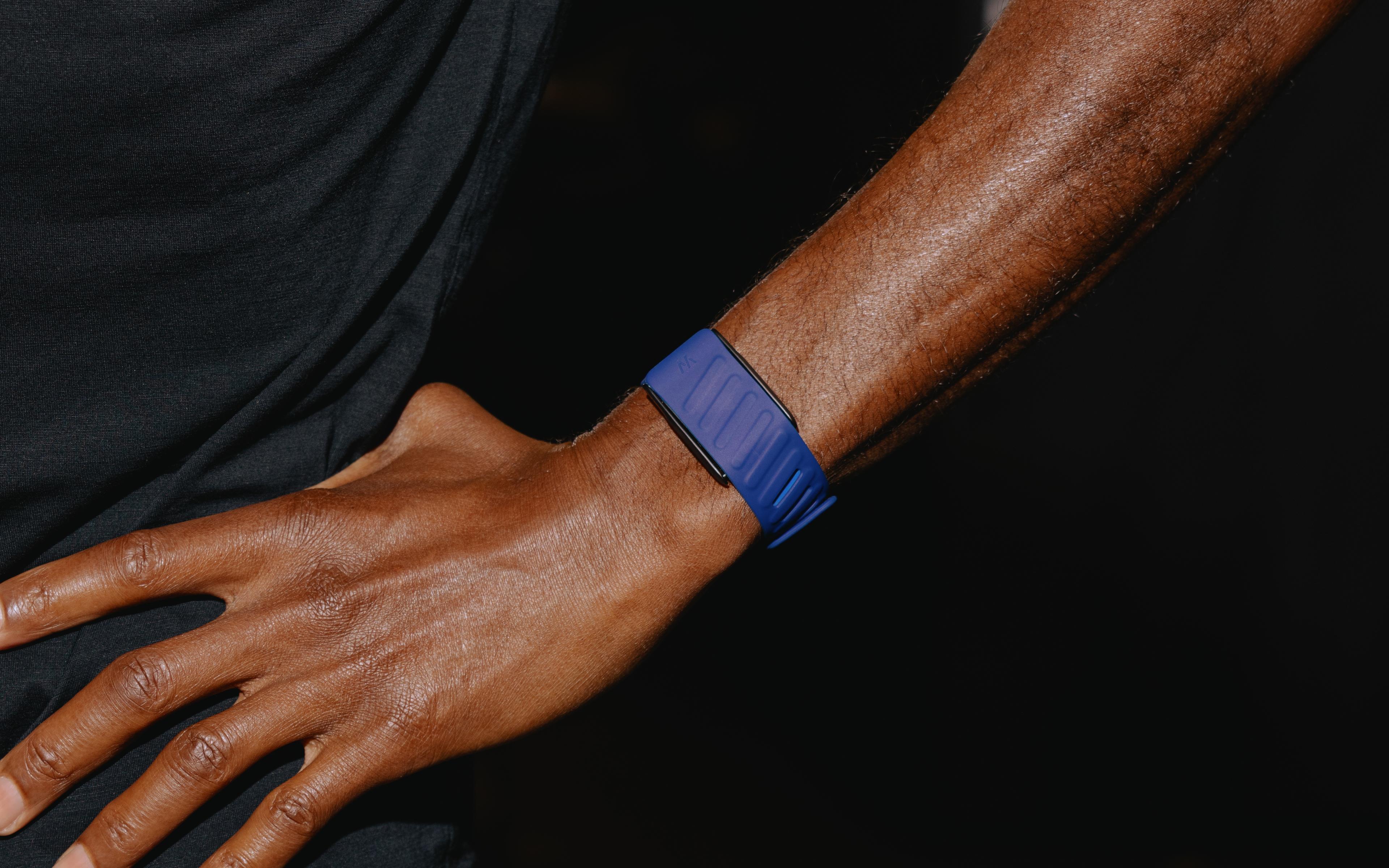 An athlete in WHOOP training kit wearing a blue WHOOP band on the wrist.