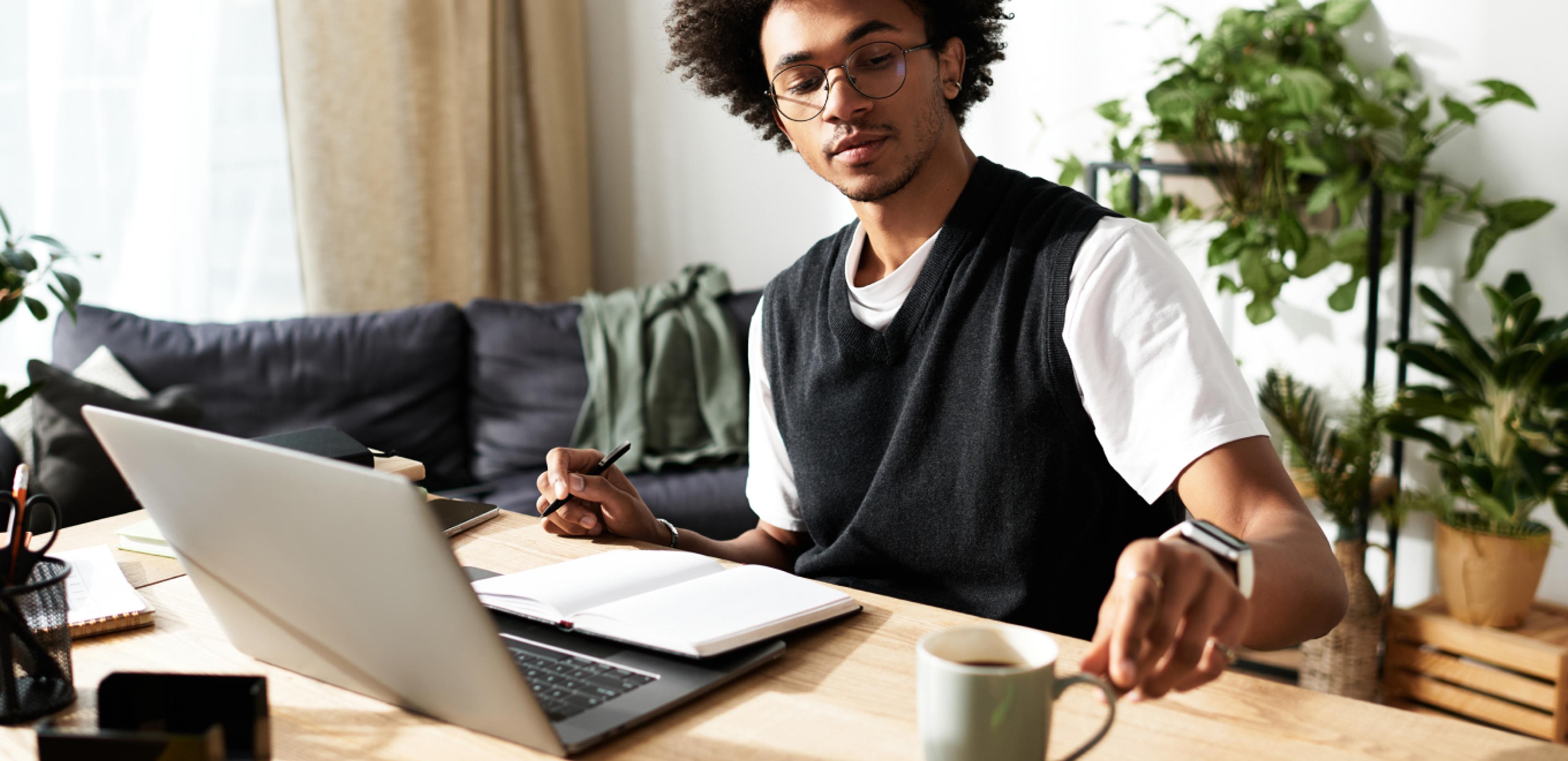 A young man researching healthcare on computer at home