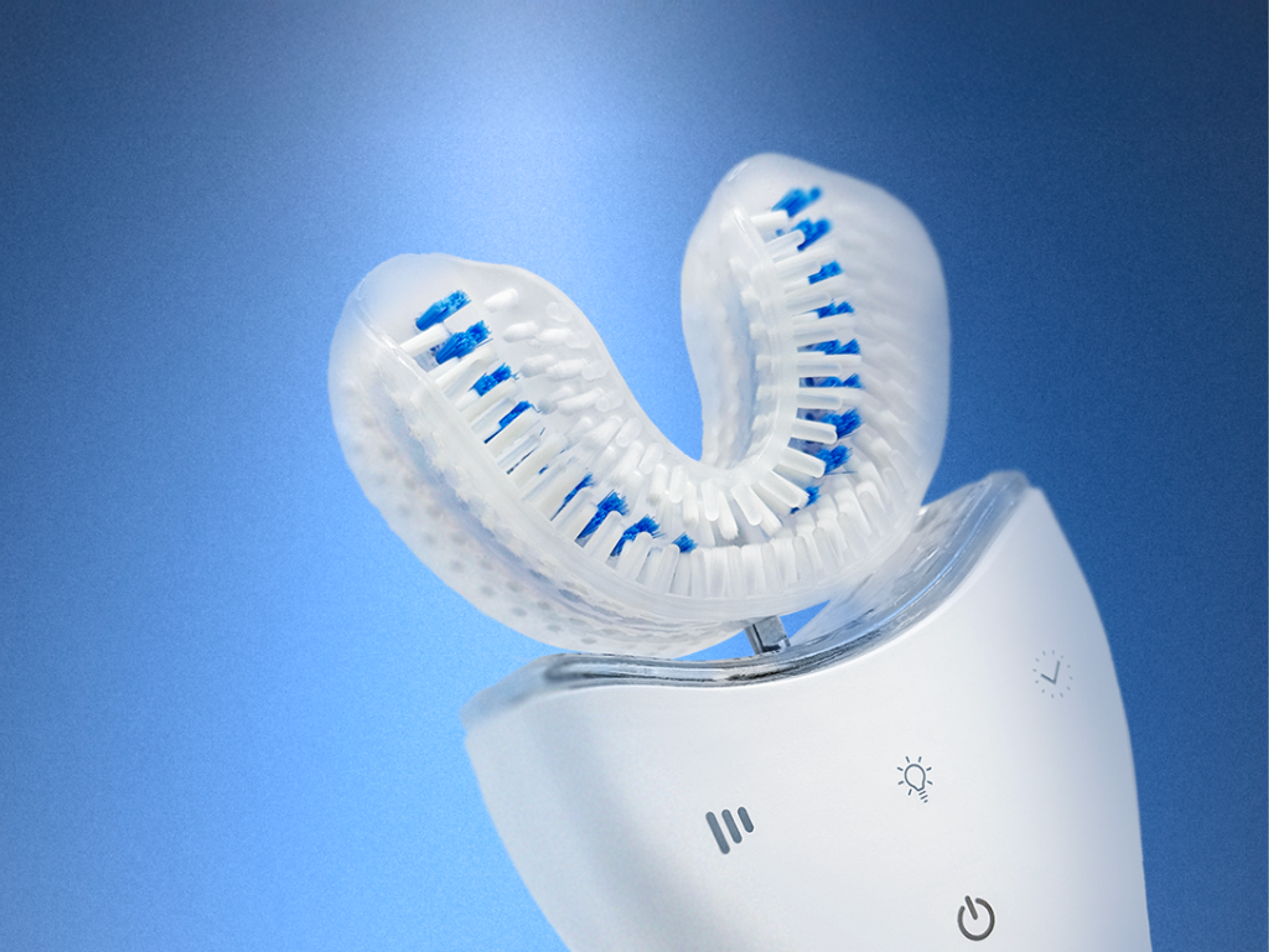 A U-shaped electric toothbrush head with white and blue bristles on a white base with control icons, against a blue background.