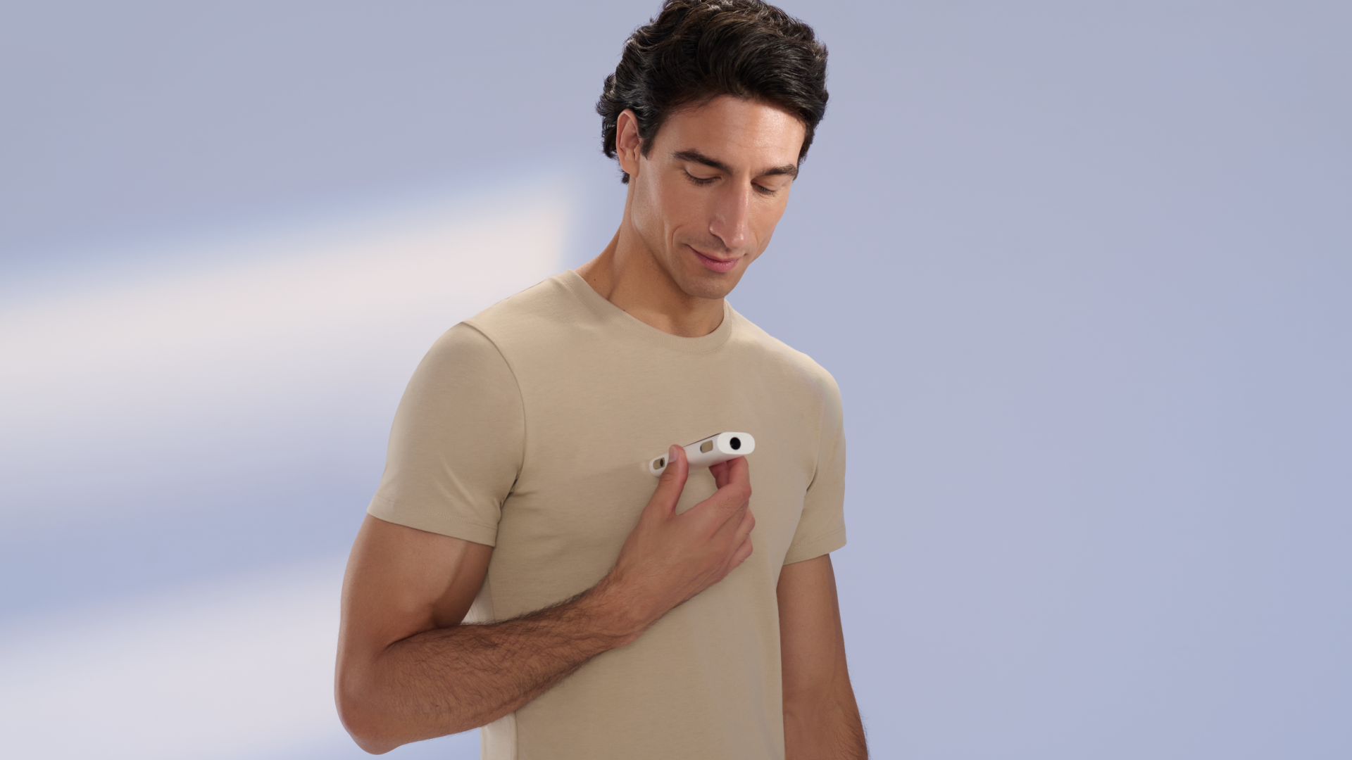 A man resting a Withings BeamO against his chest to take a reading.