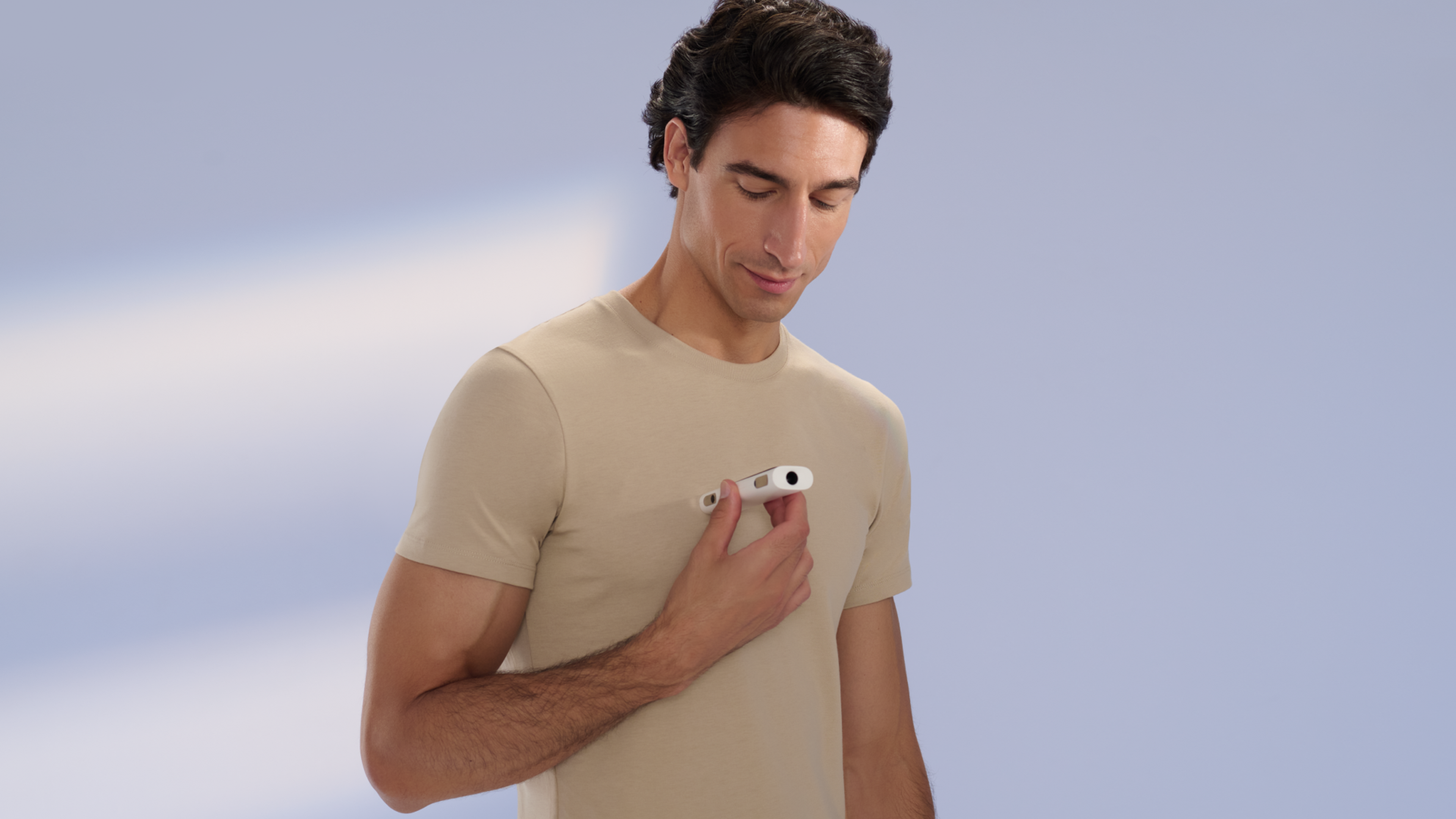 A man resting a Withings BeamO against his chest to take a reading.