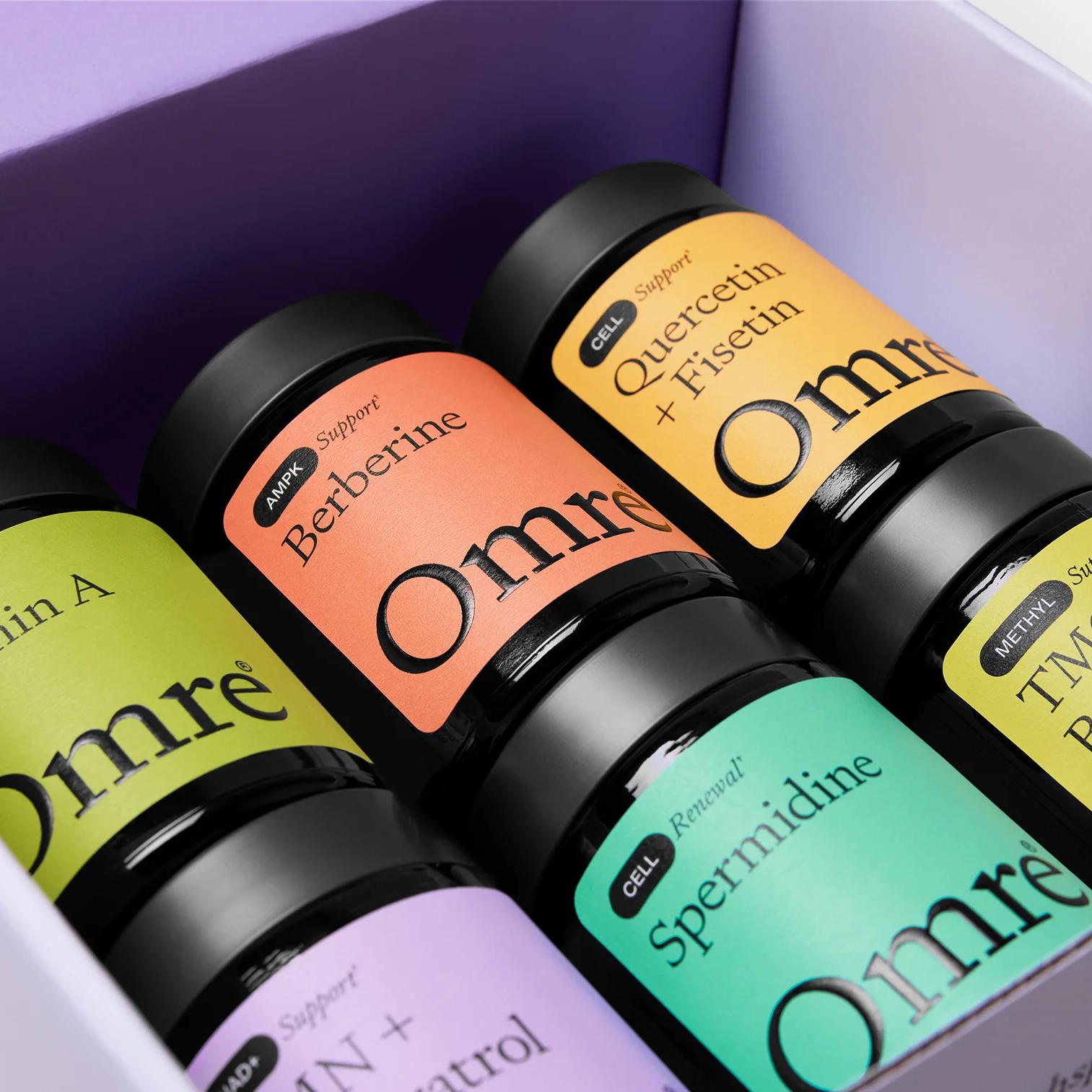 Six Omre supplement bottles with colorful labels in an open purple box.