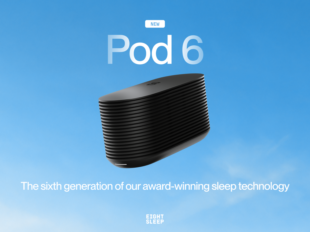 A black "DEEP SLEEP" smart device sits on the floor beside a bed in a room overlooking the ocean.