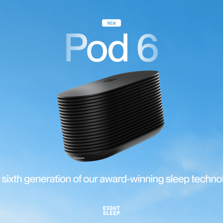 A black "DEEP SLEEP" smart device sits on the floor beside a bed in a room overlooking the ocean.
