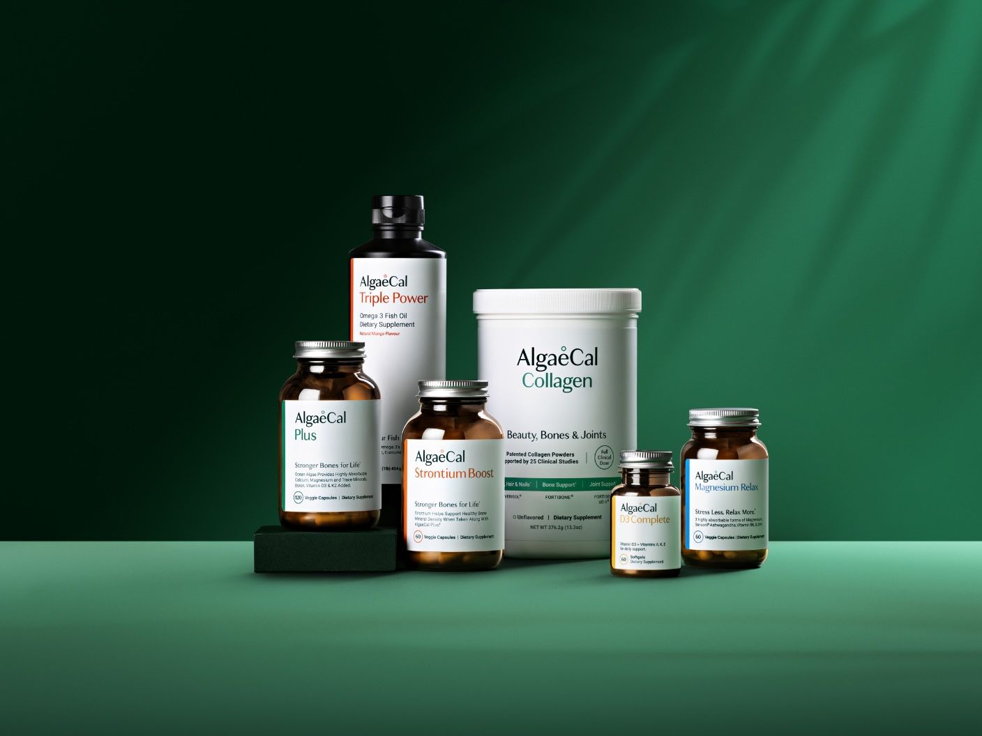 AlgaeCal supplements: Triple Power, Plus, StrontiumBoost, Collagen, D3 Complete, and Magnesium Relax, arranged on a green background.