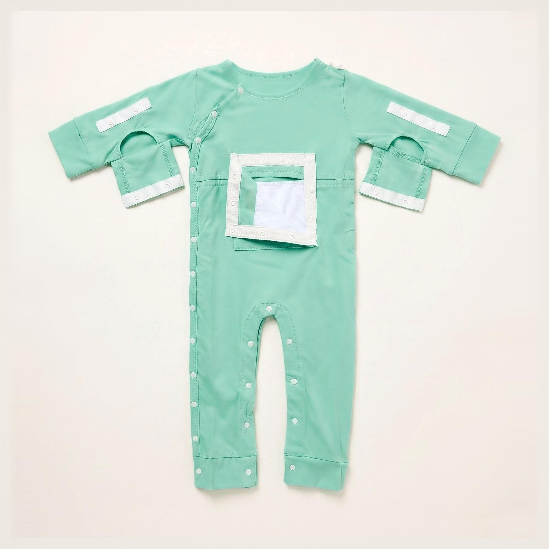 Mint green baby one-piece with full-length snaps, a rectangular chest opening, and open sleeves with white velcro tabs.