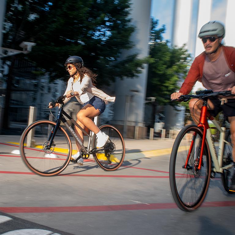 Man and woman cycling with motion blur.