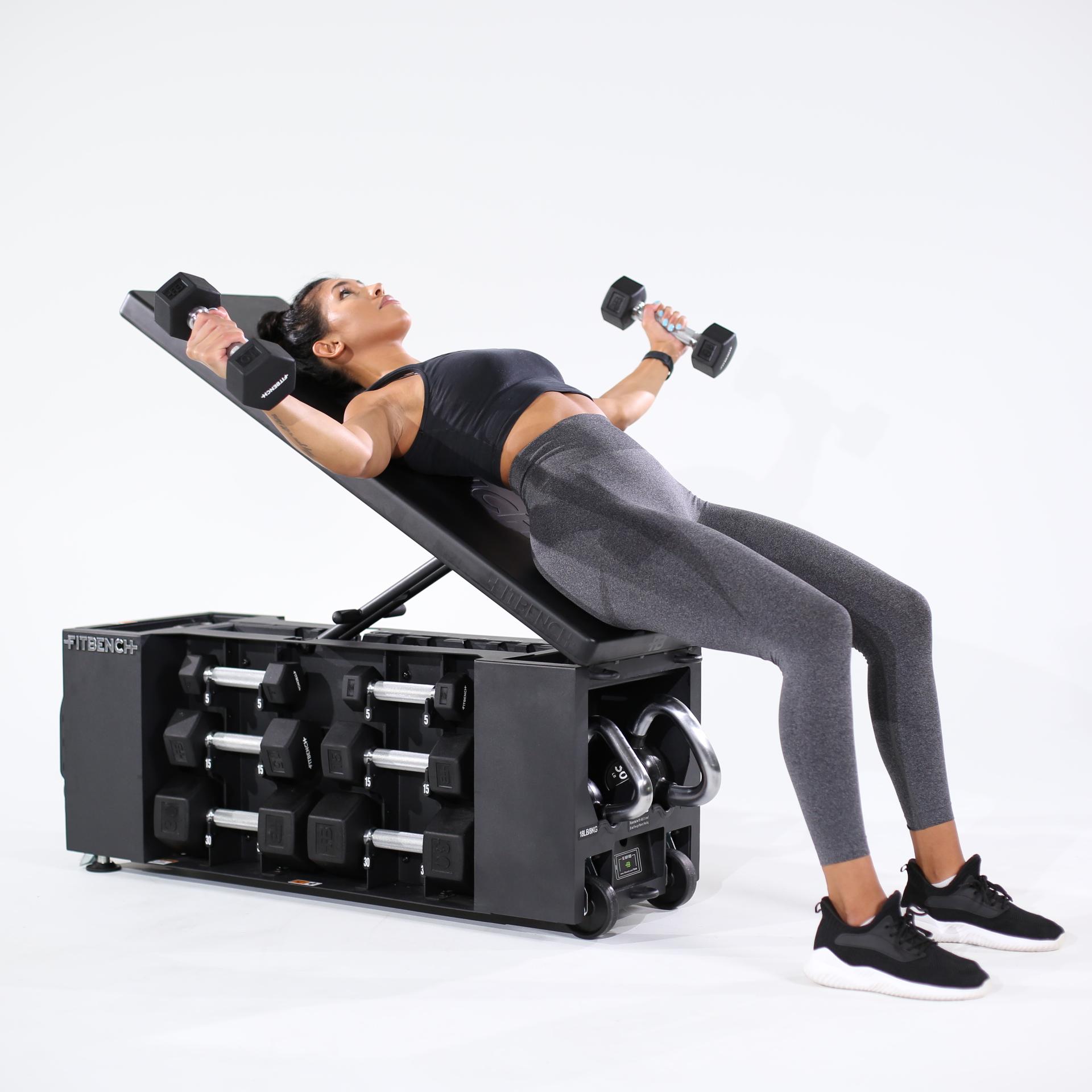 Woman performs dumbbell flyes on an incline bench with integrated storage.