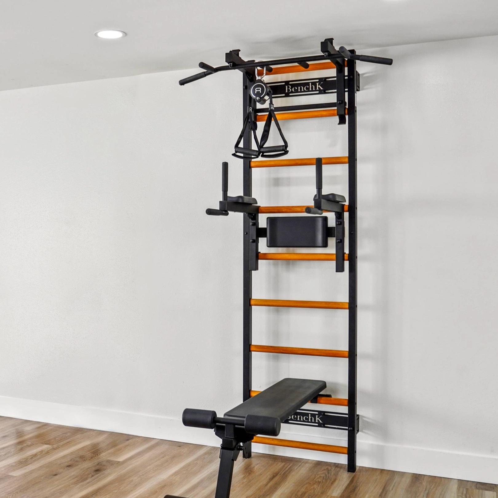 BenchK wall-mounted fitness system with a Swedish ladder, pull-up bar, dip station, and workout bench.