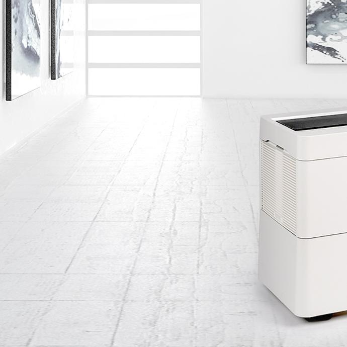 Sleek white device with a black top panel in a modern minimalist room.