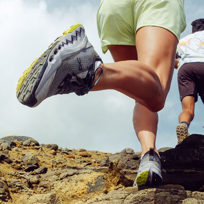 Woman running up mountain wearing On Running shoes from Backcountry