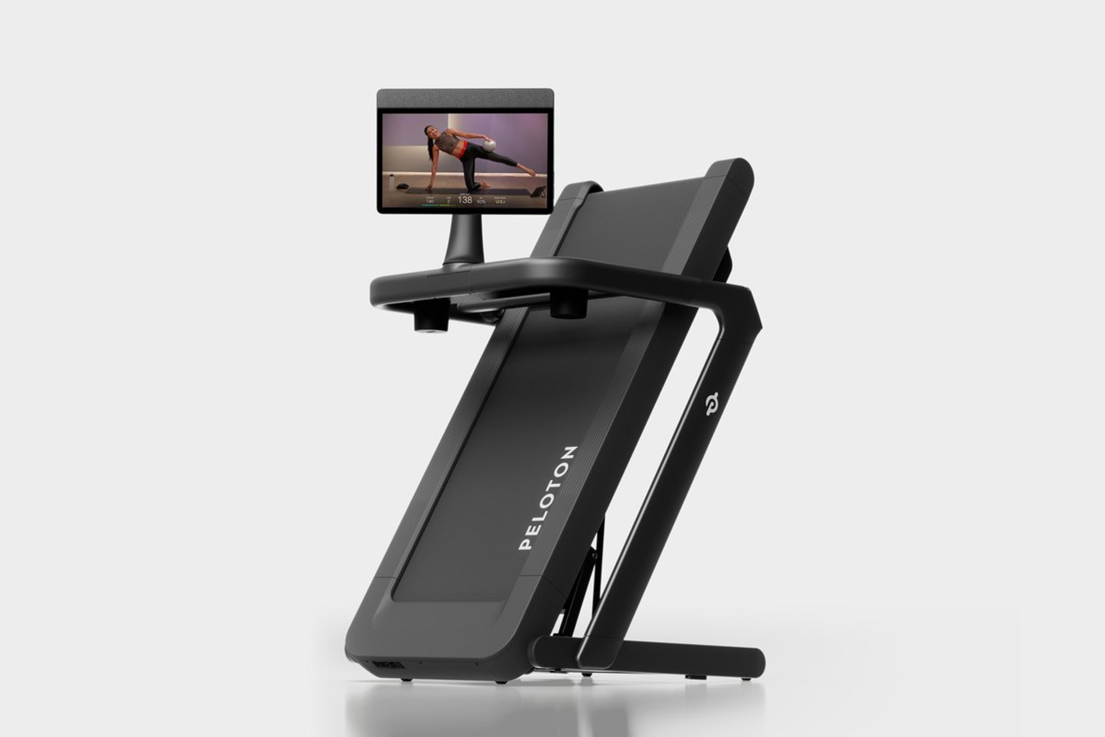 The Peloton Tread Flex, folded upright with a class on screen.