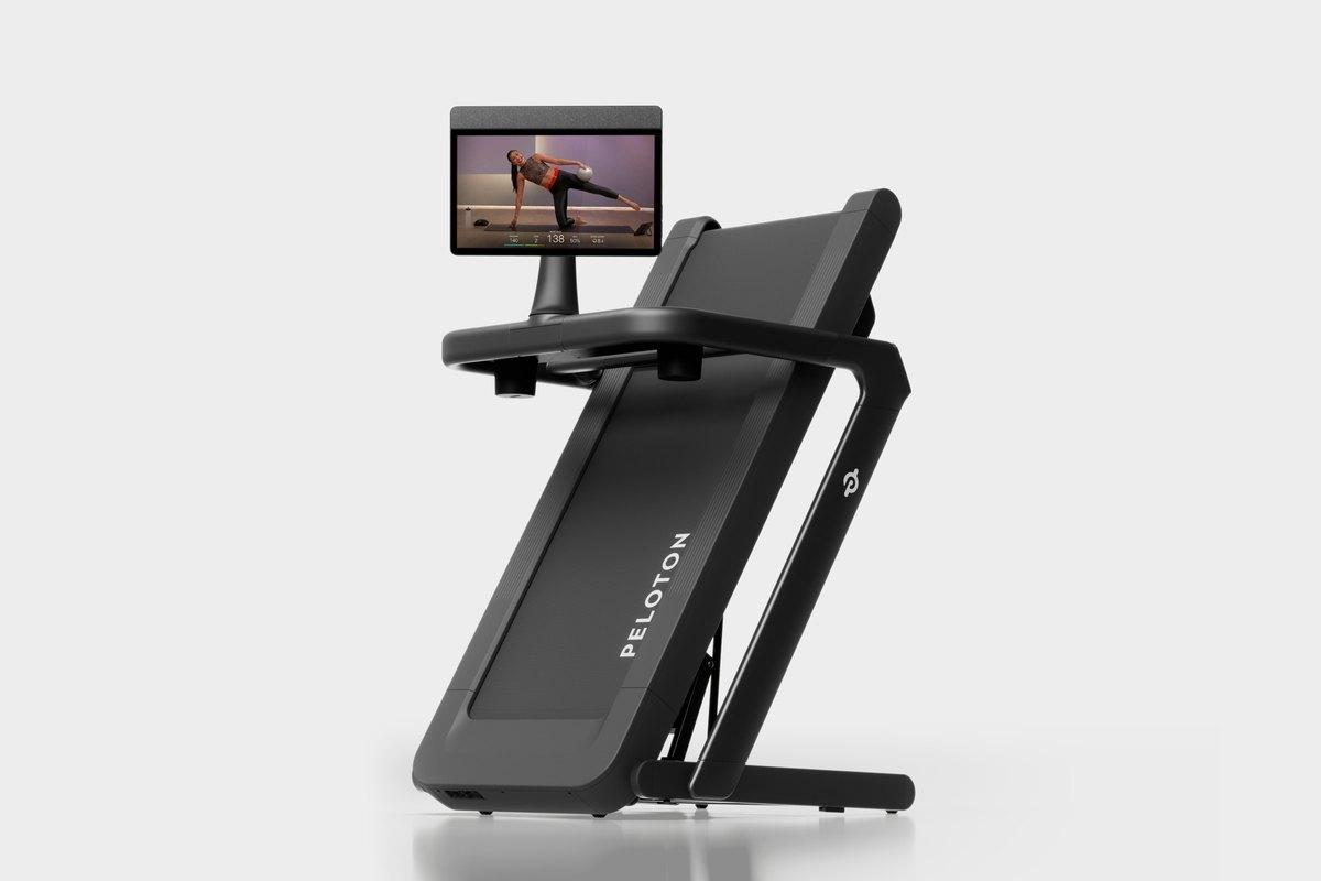 The Peloton Tread Flex, folded upright with a class on screen.
