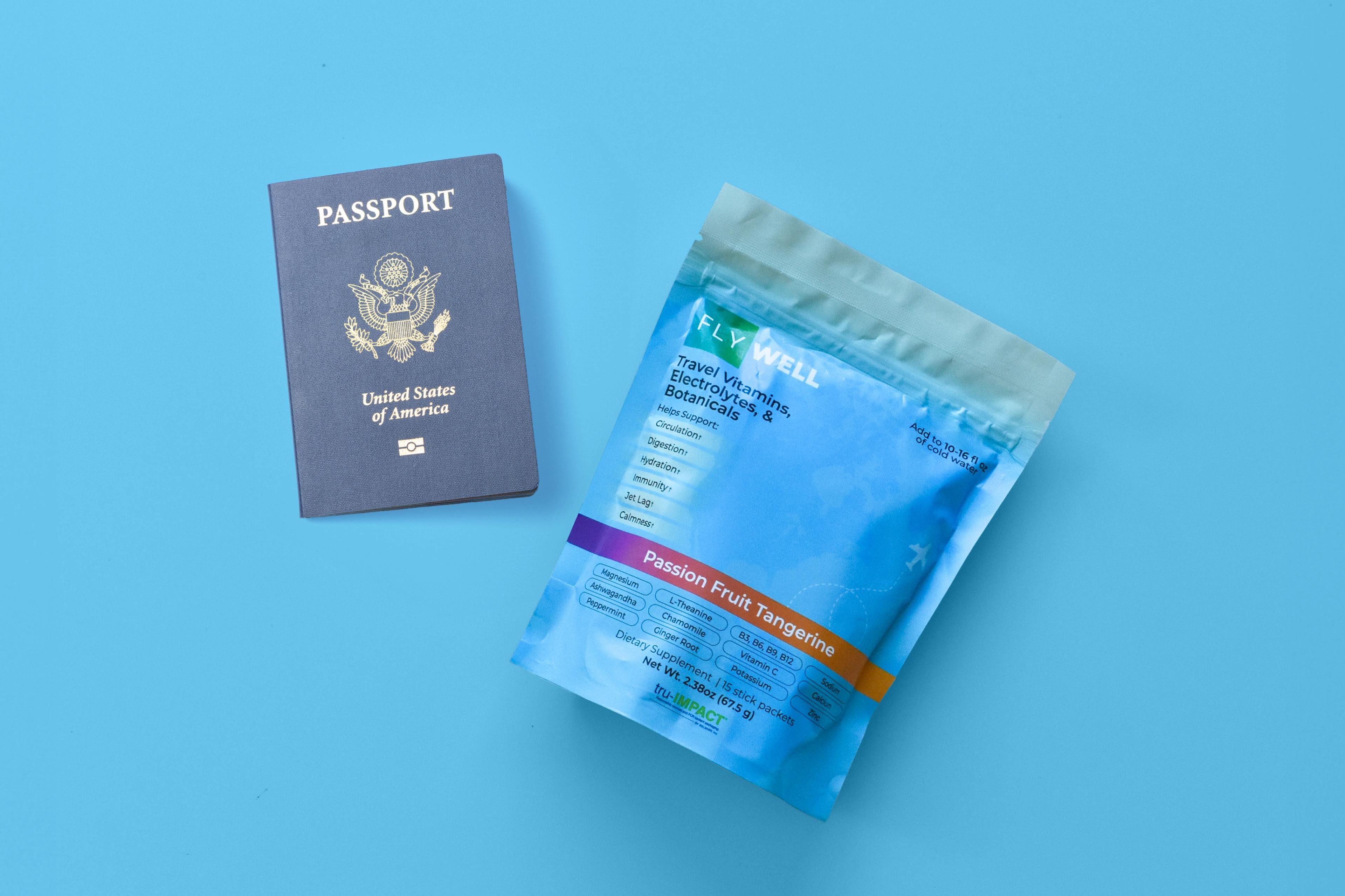 A US passport and a packet of Fly Well travel vitamins on a blue background.