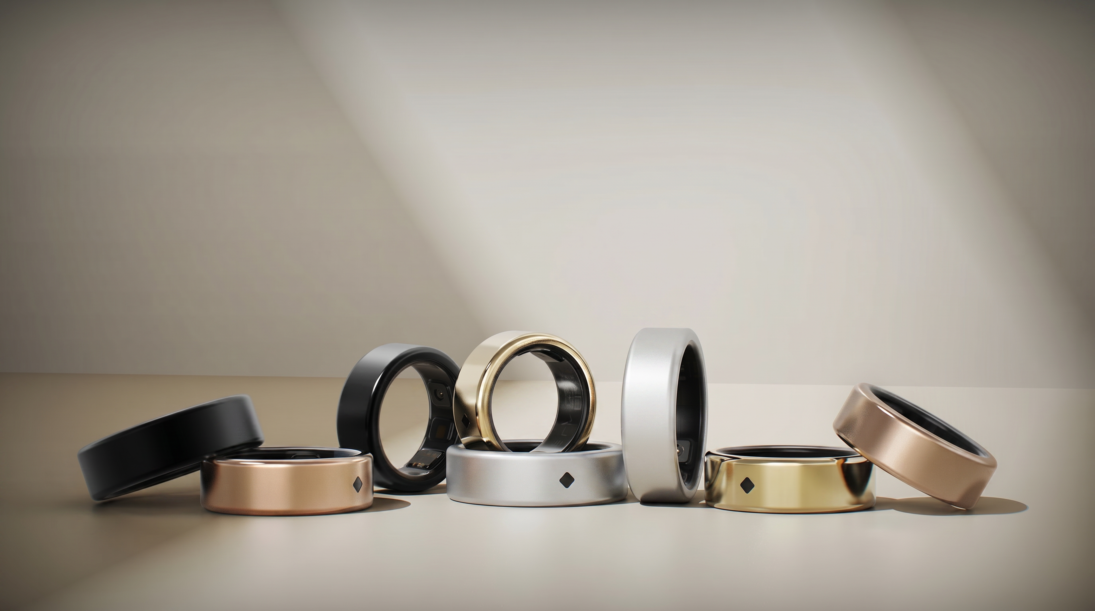 Eight smart rings in black, rose gold, silver, and gold finishes.