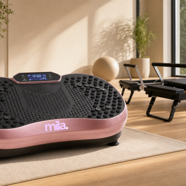 Rose gold "mila." vibration plate in a modern studio with pilates reformers.