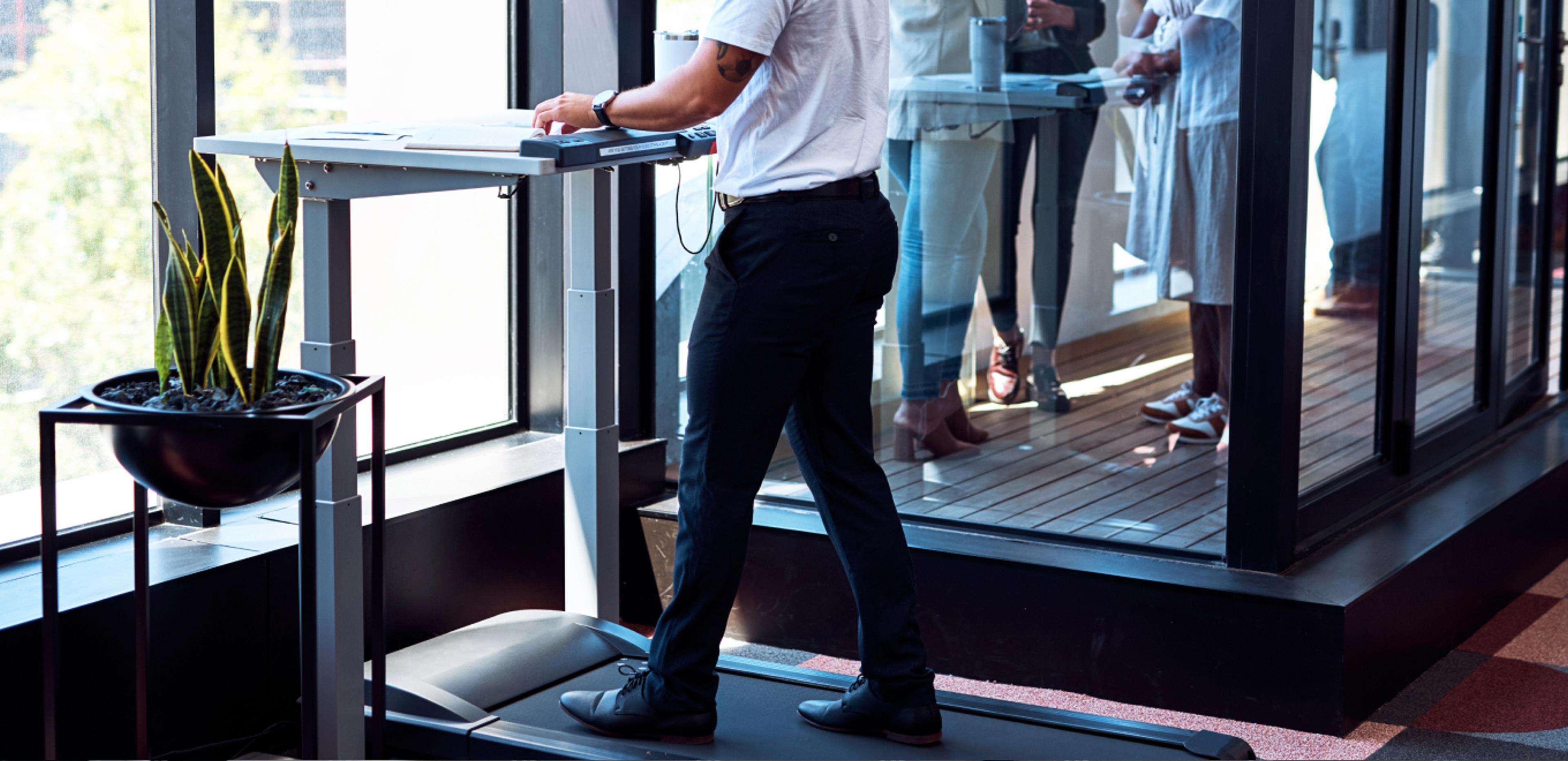 Businessperson using a walking pad while working at the office