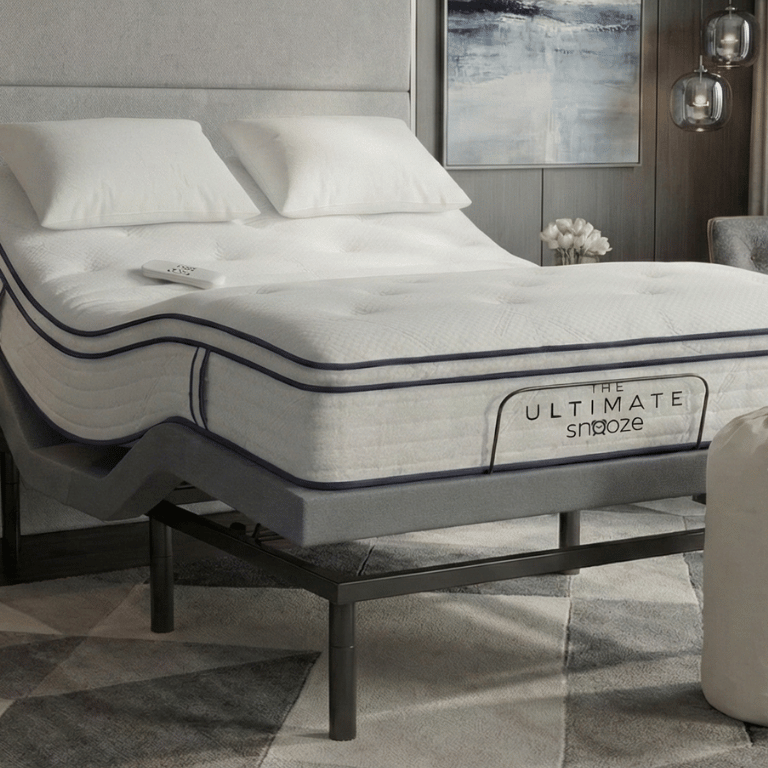 An adjustable bed featuring "The Ultimate Snooze" mattress, a remote, and a matching branded storage bag.