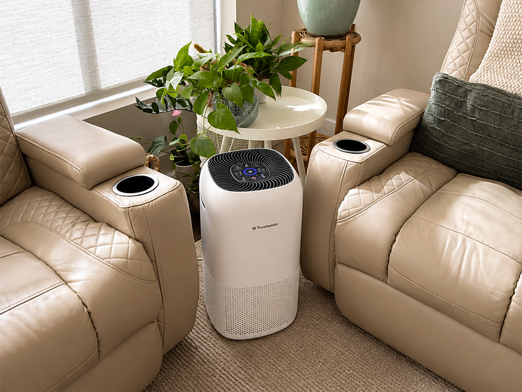 A white air purifier stands between two tan leather recliners.