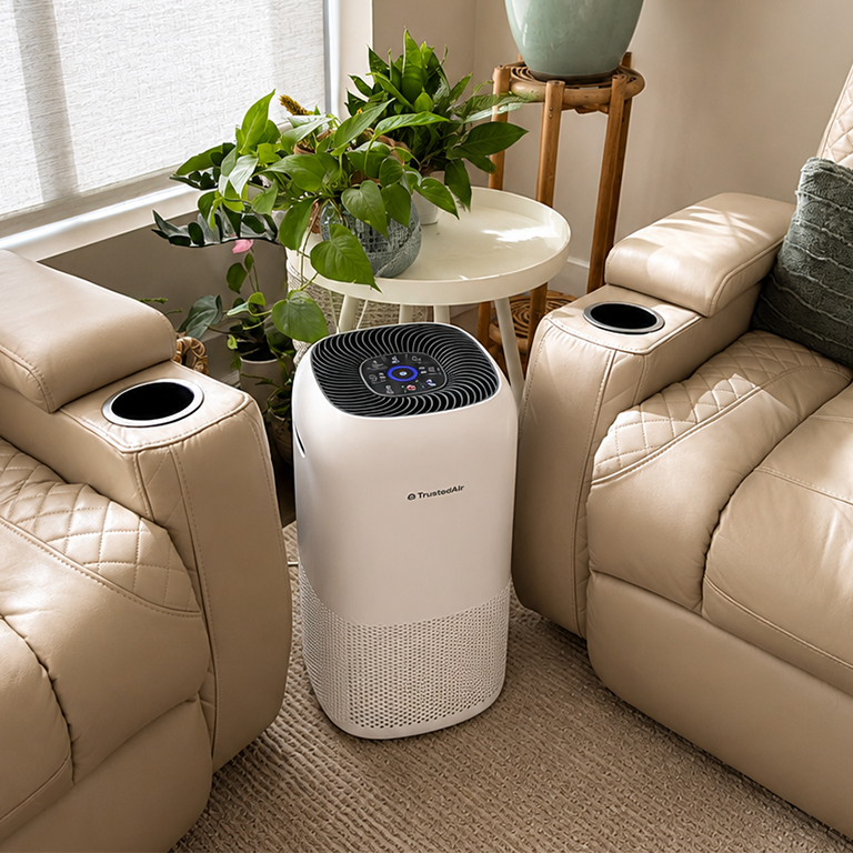 A white air purifier stands between two tan leather recliners.